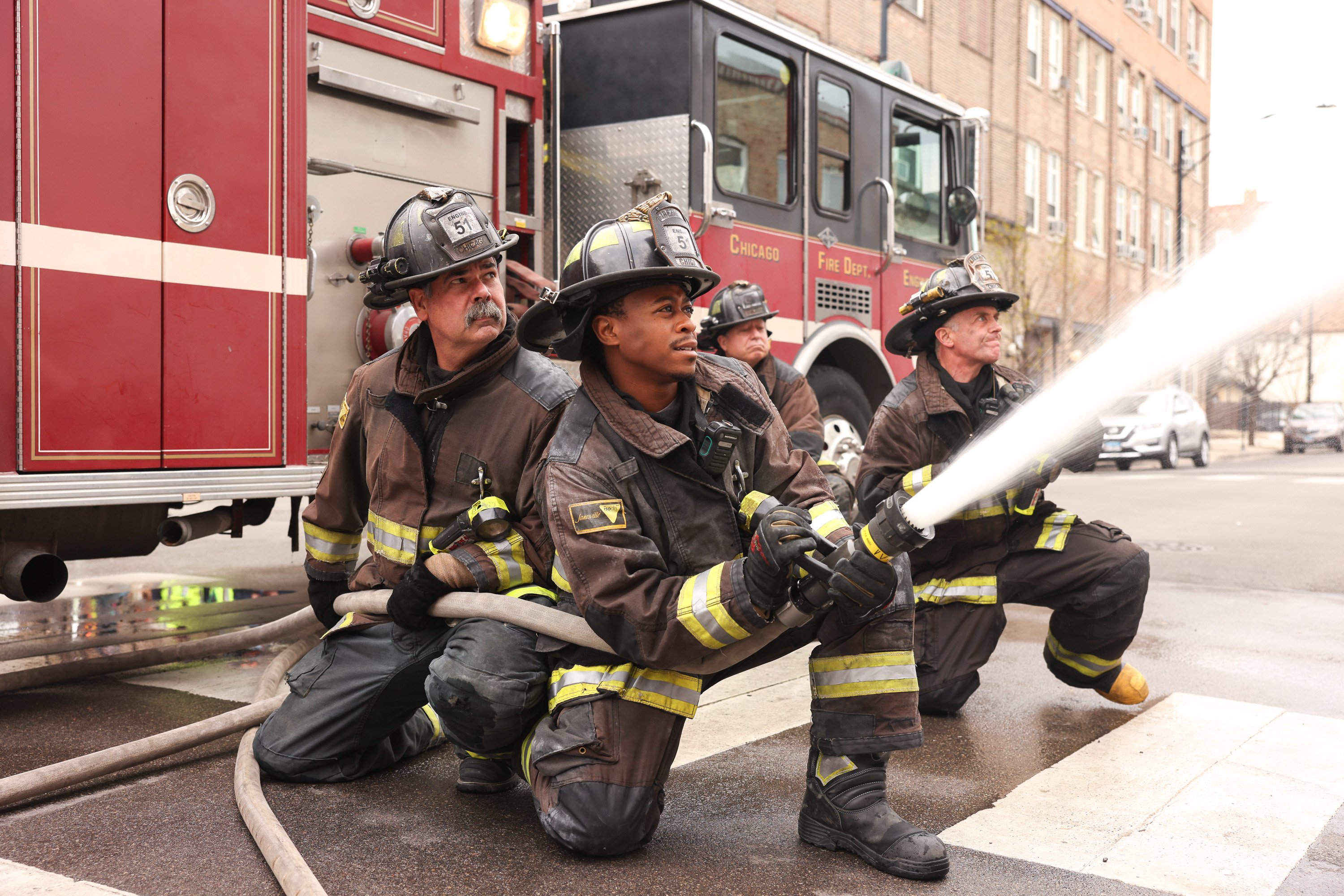the cast of 'Chicago Fire', including Daniel Kyri and David Eigenberg shoot water at a fire during season 9
