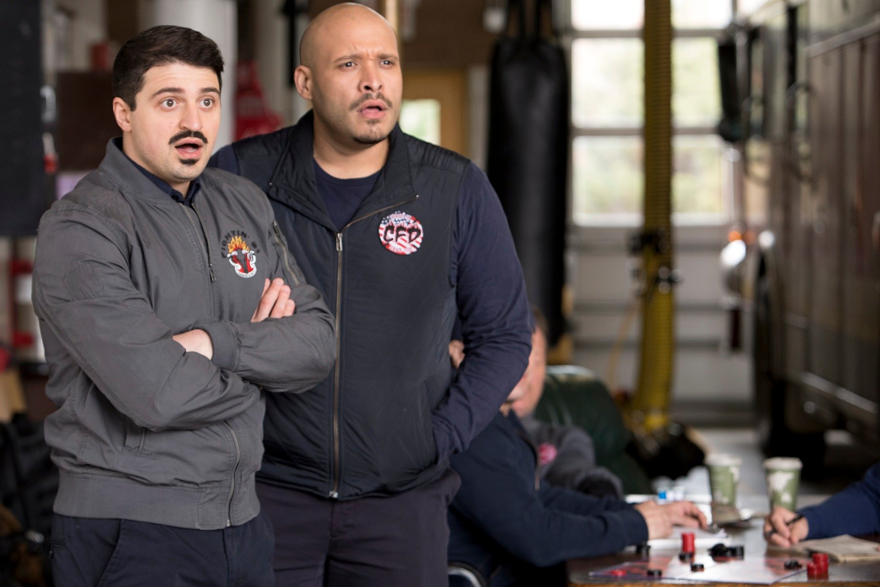 Yuri Sardarvo as Brian 'Otis' Zvonecek and Joe Minoso as Joe Cruz stand in the firehouse during a season 7 episode of 'Chicago Fire'
