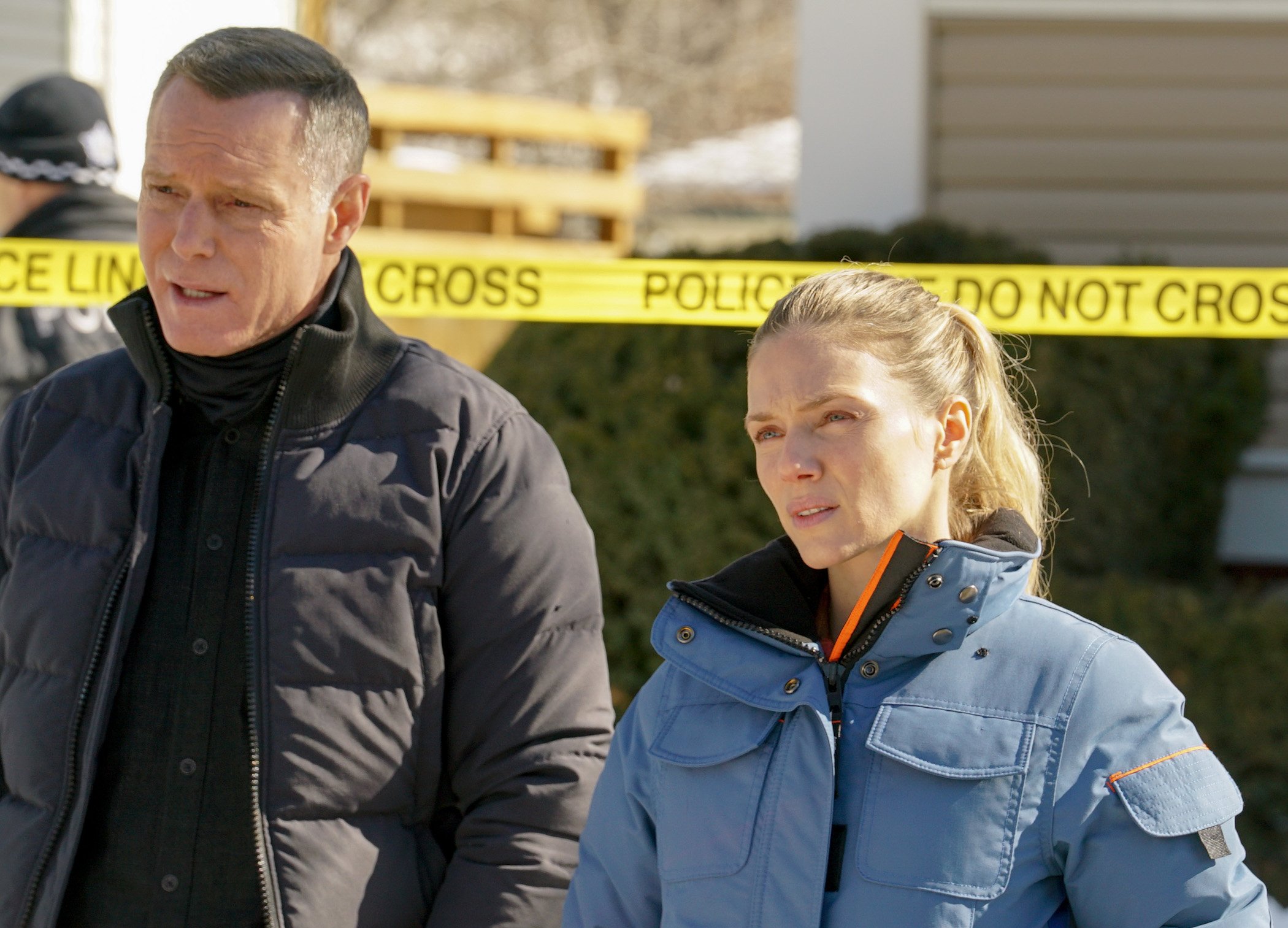Hank Voight and Hailey Upton, two stars of 'Chicago P.D.' Season 9, standing next to each other in front of police tape