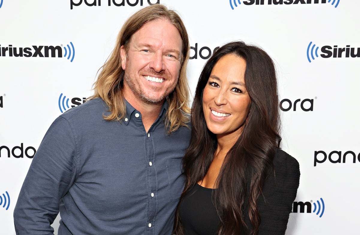 Chip Gaines smiles and poses alongside Joanna Gaines wearing black in 2021