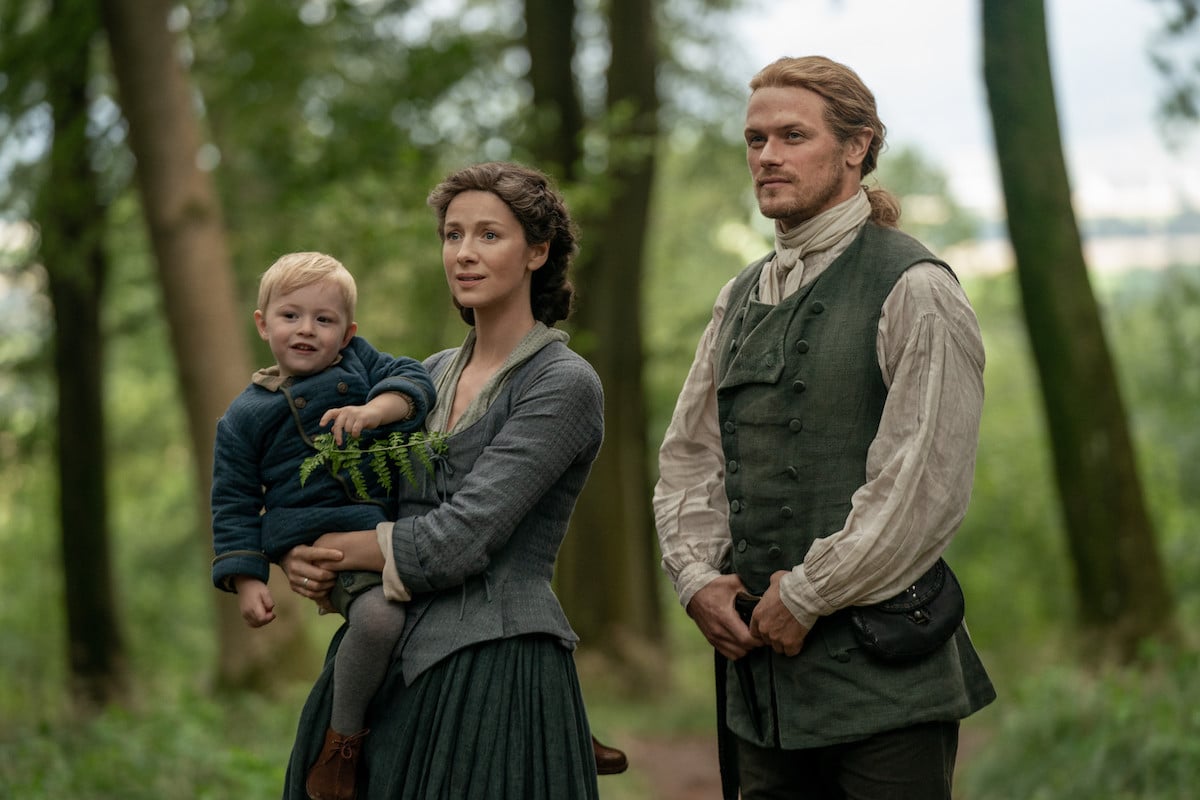 Claire holding baby and standing next to Jamie in 'Outlander' Season 5. The Frasers' lives will be complicated by 'Outlander's Tom Christie and his family in 'Outlander' Season 6. And the trouble will seriously impact Jamie and Claire.