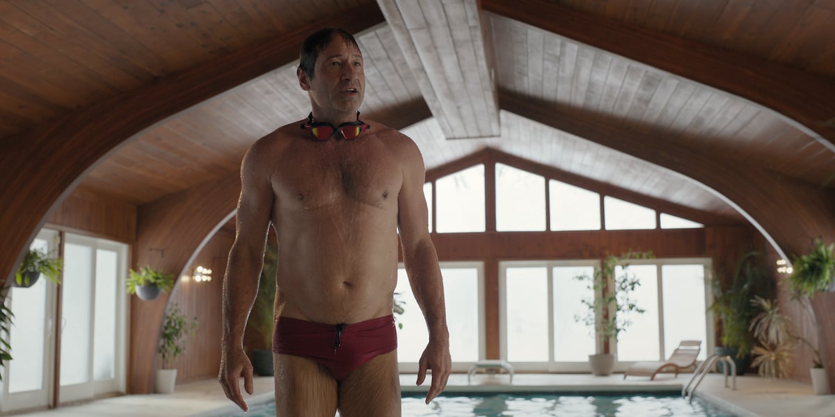 David Duchovny stands next to a pool wearing a Speedo in 'The Chair' Season 1