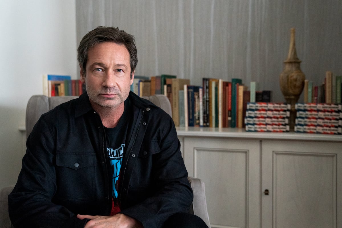 David Duchovny sits in a chair with books behind him in 'The Chair'