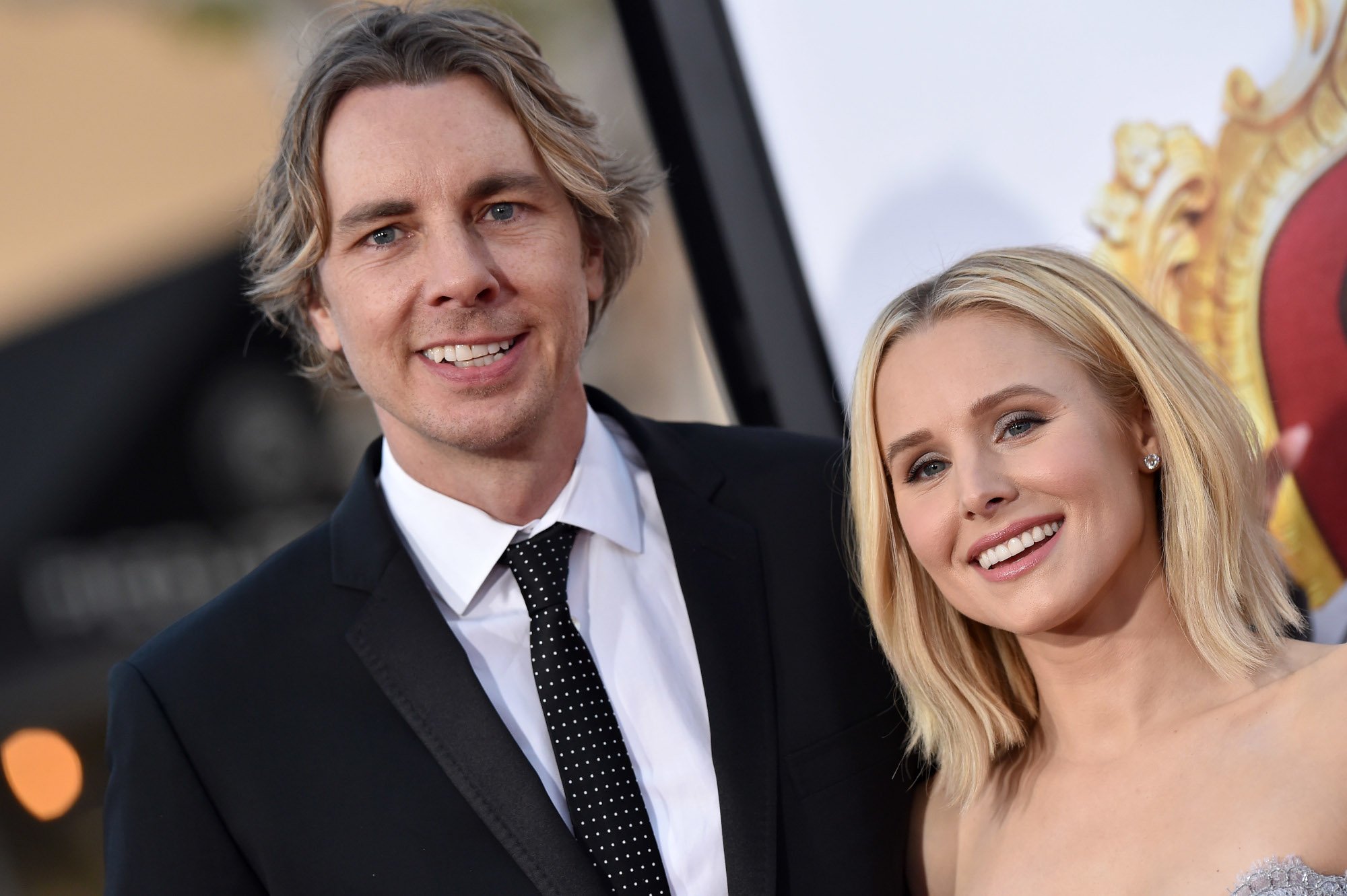 Dax Shepard and Kristen Bell on the red carpet. He's wearing a white shirt, black suit, and black tie and she's wearing a sleeveless dress.