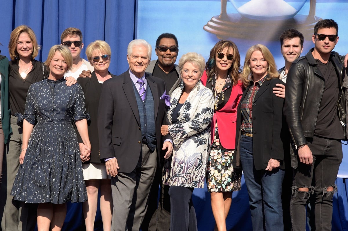 The cast of 'Days of Our Lives' post for a group photo at a fan club event in 2018.