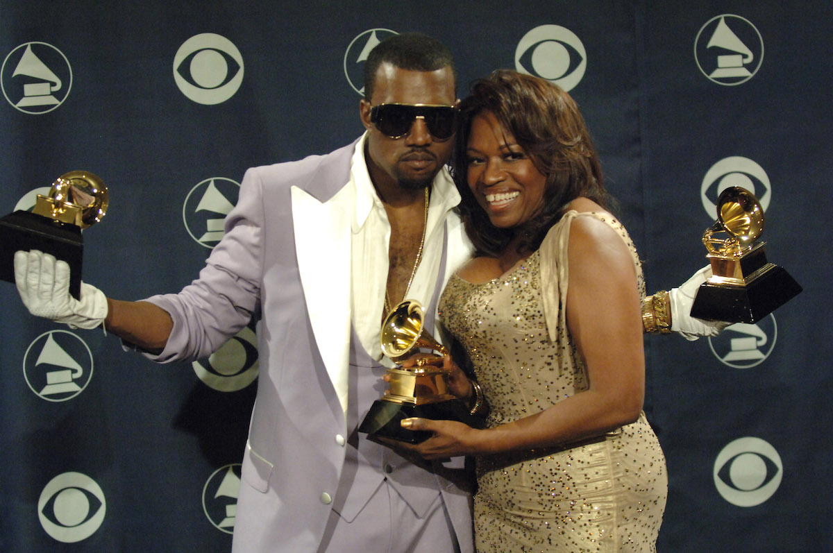 Kanye West and his mother Donda holding three Grammy awards.