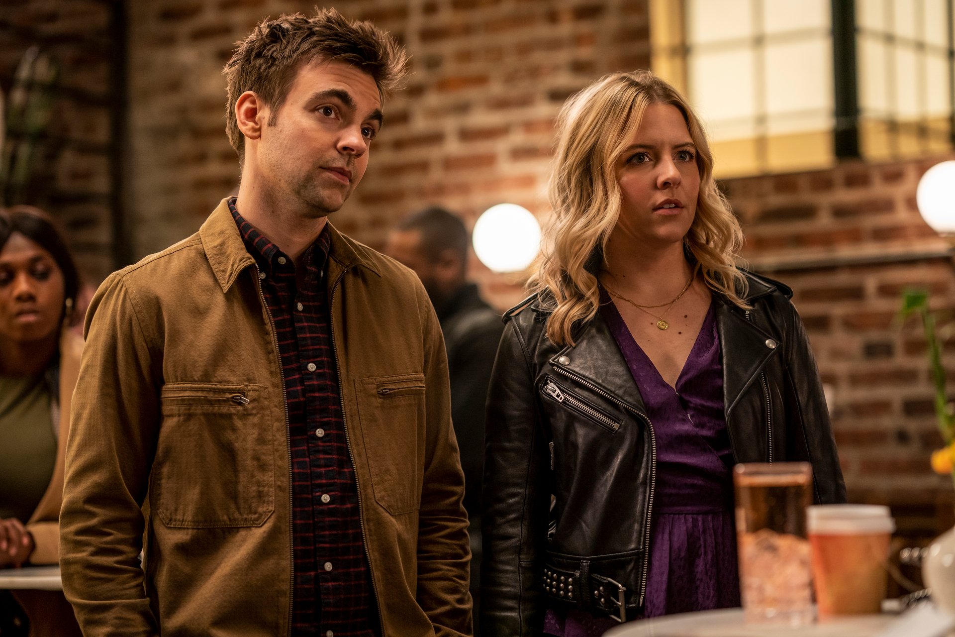 Drew Tarver and Heléne Yorke stand in a bar with brick walls in 'The Other Two.'