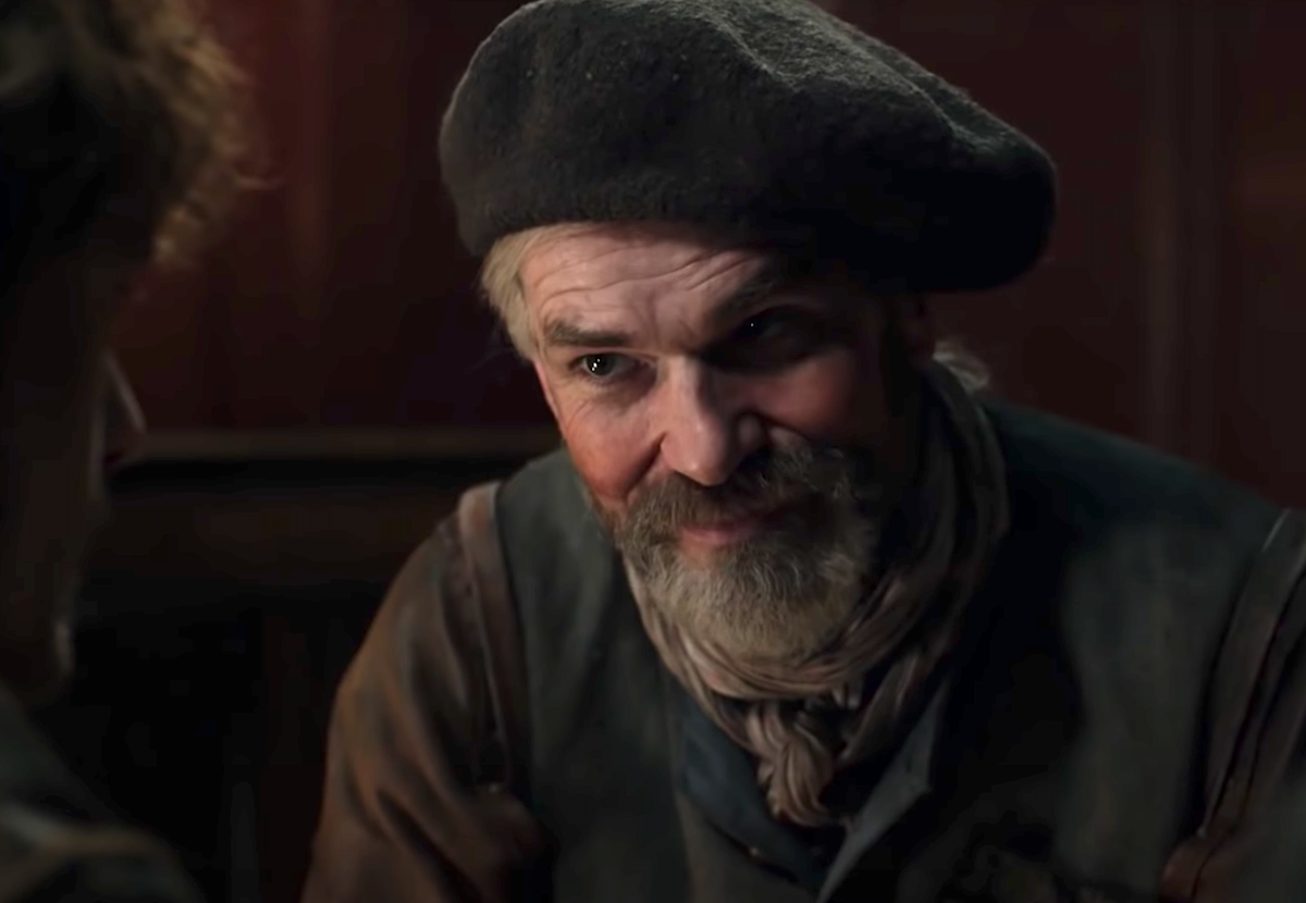 Duncan Lacroix as Murtagh Fitzgibbons in 'Outlander.' He sits in a room with brown wooden walls. He wears colonial clothes with a grey cap, his grey hair in a low ponytail. Lacroix played Murtagh for four seasons of 'Outlander,' and fans are wondering if he'll be in the 'Outlander' Season 6 cast.
