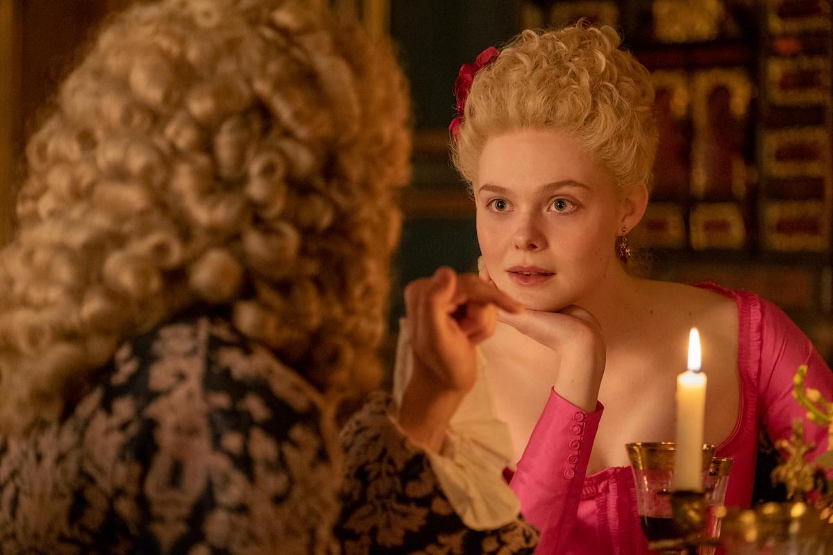 Elle Fanning as Catherine, wearing a pink dress and talking to Voltaire, in 'The Great' Season 1 finale