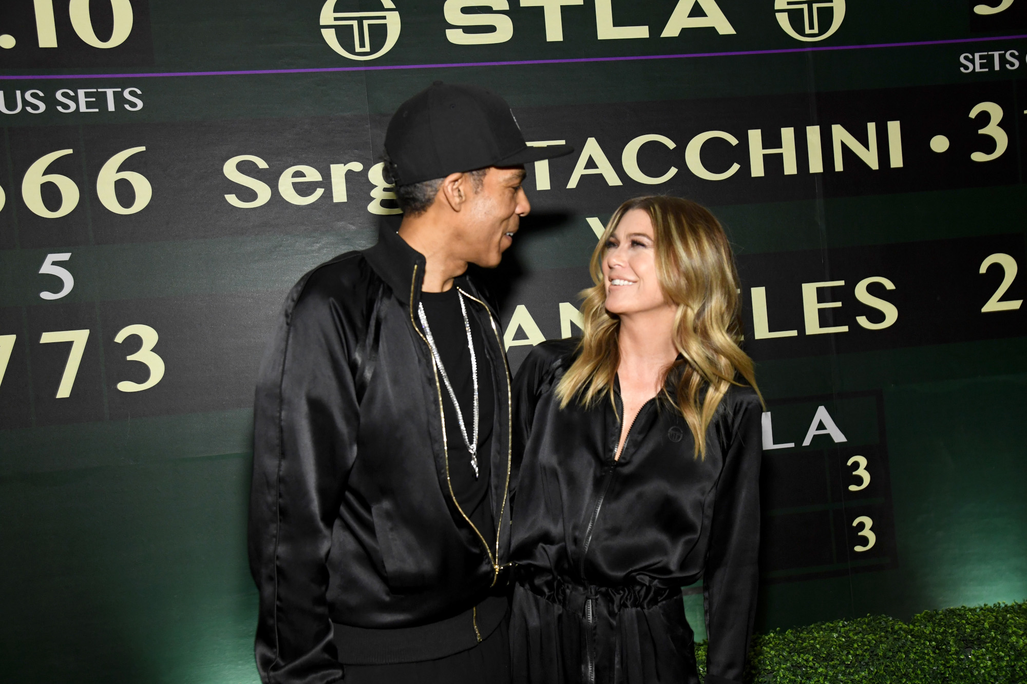 Grey's Anatomy star Ellen Pompeo with husband Chris Ivery. Both are wearing black formalwear and smiling while looking into each other's eyes.