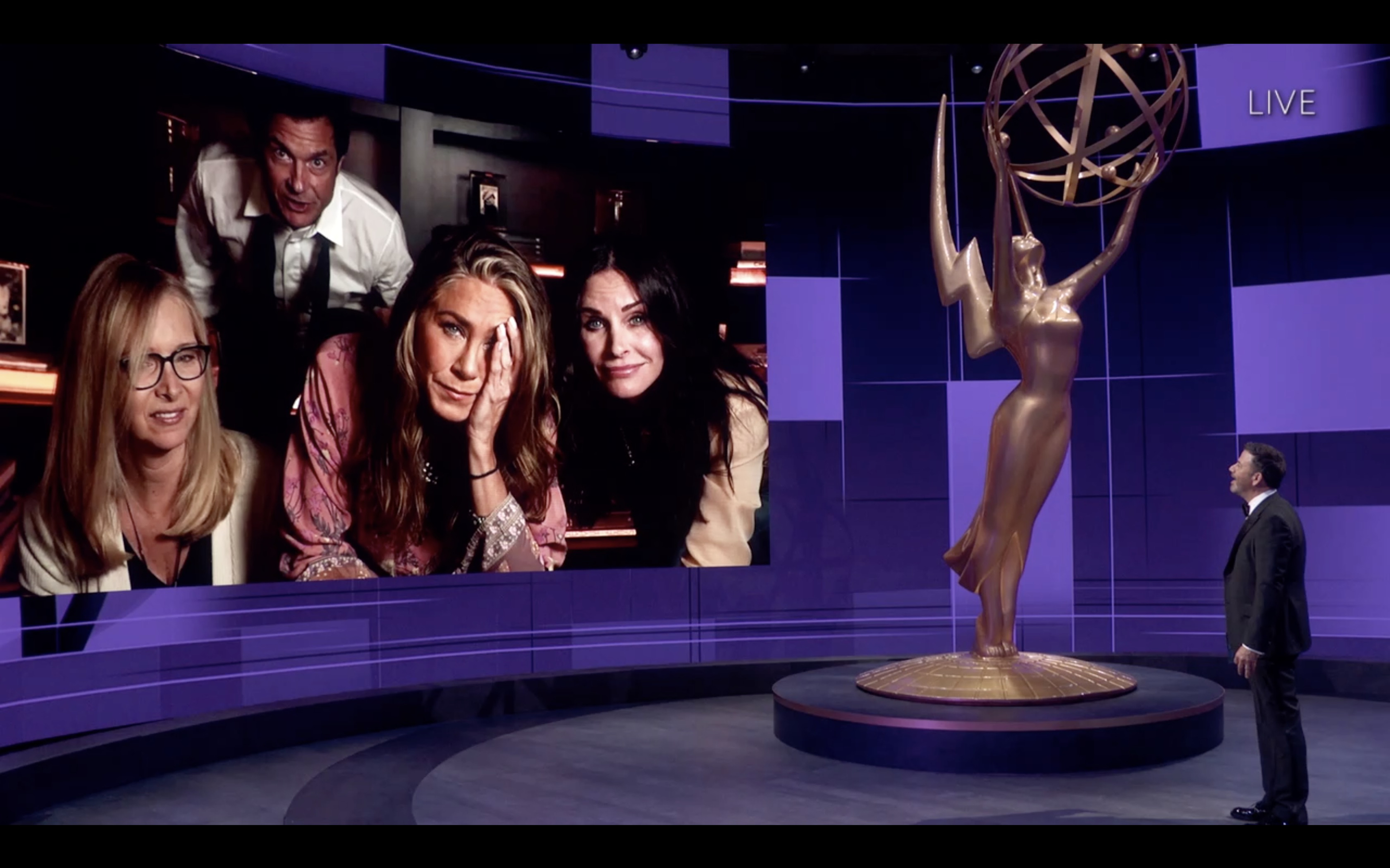 Lisa Kudrow, Jennifer Aniston, Courteney Cox and Jason Bateman attend the 72nd Annual Emmy Awards via Zoom. Jimmy Kimmel is standing on the stage