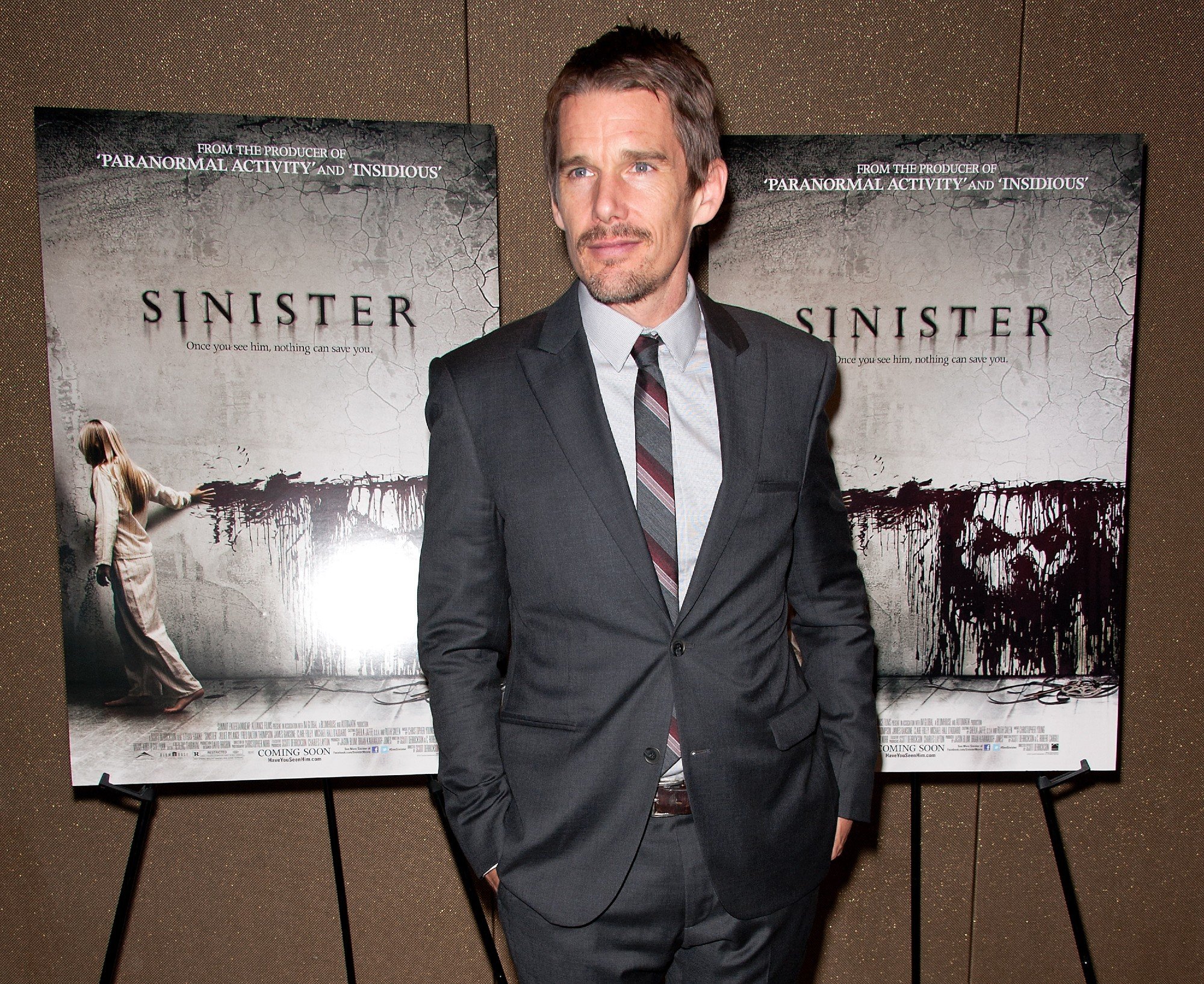 Ethan Hawke posing in front of 'Sinister' posters at the premiere