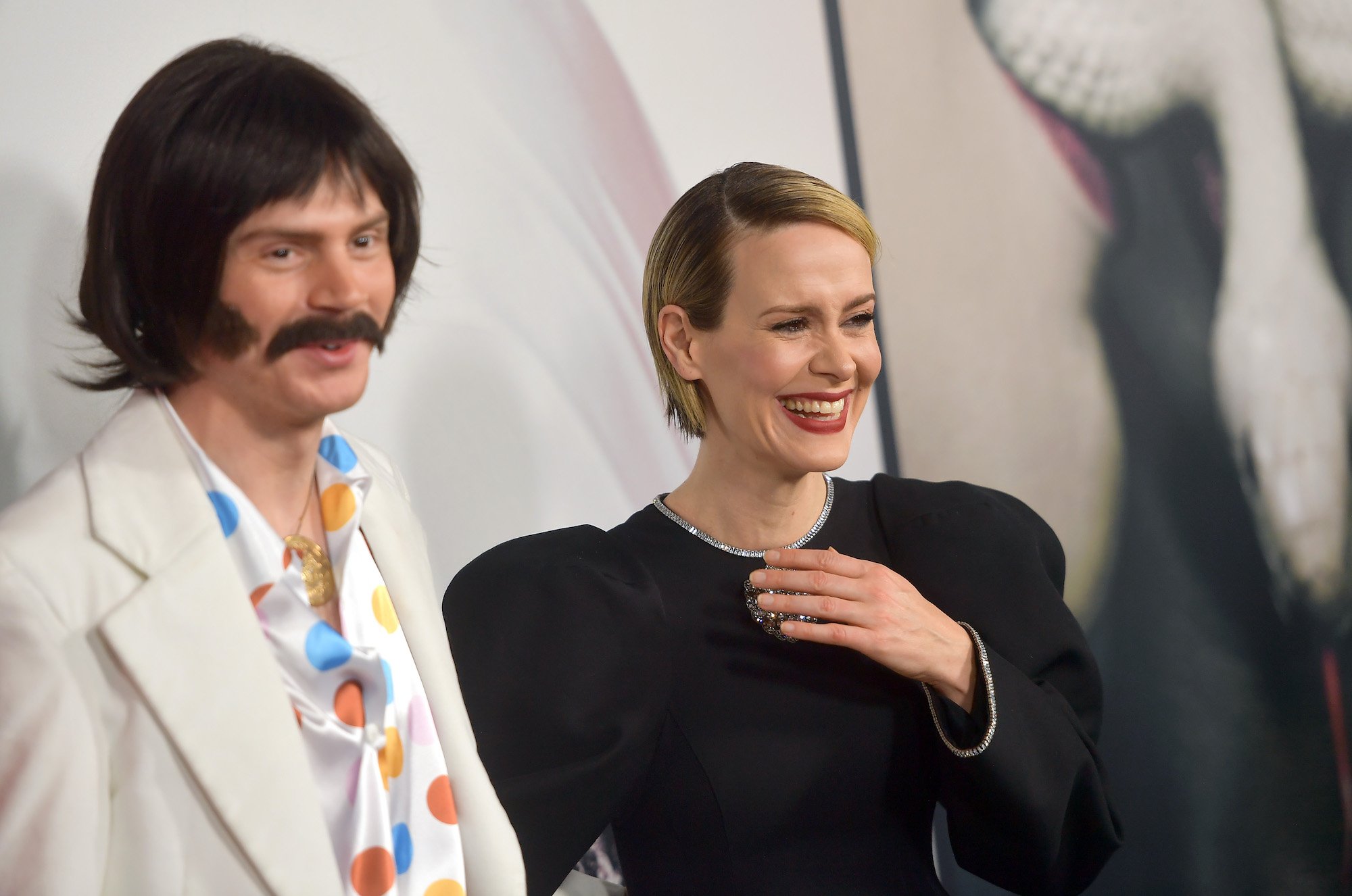 (L-R) Evan Peters and Sarah Paulson from 'American Horror Story' Season 10 cast laughing together at a party for the show