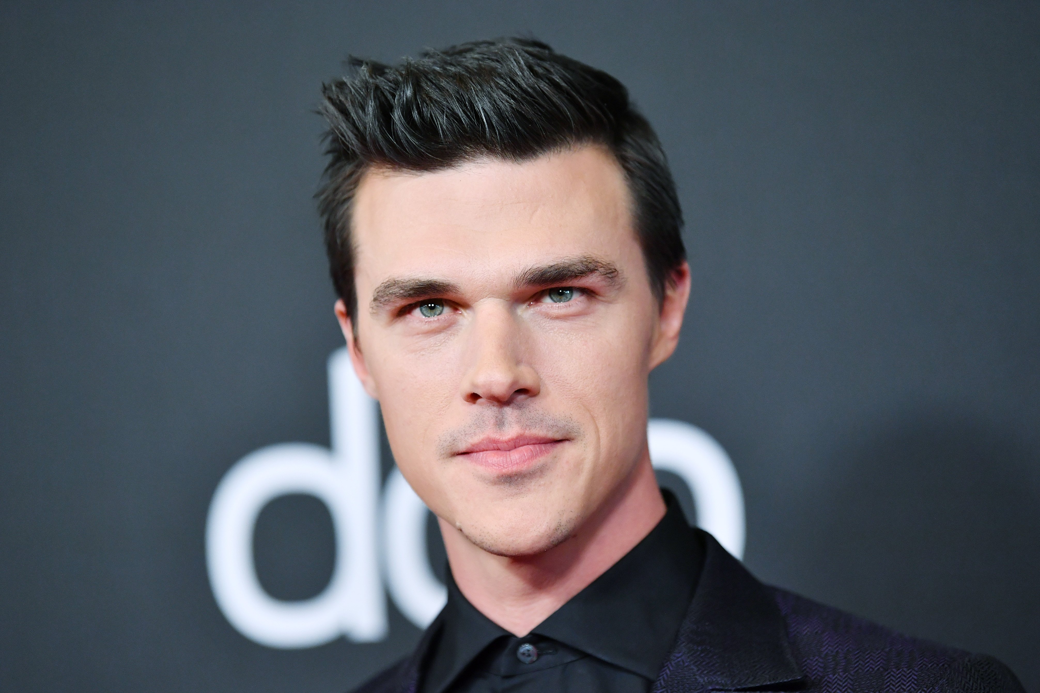 Finn Wittrock in a black shirt.