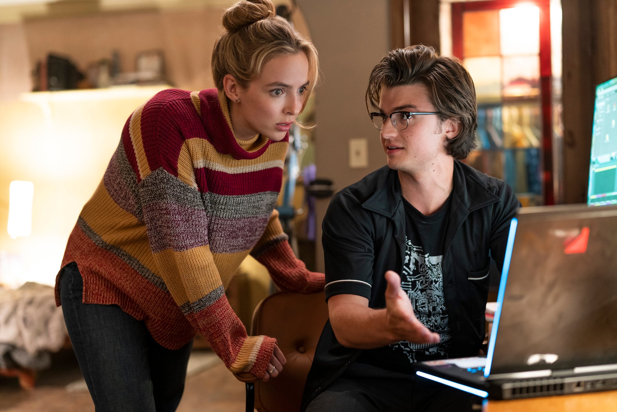 Jodie Comer and Joe Keery watch a computer screen in a scene from 'Free Guy.'