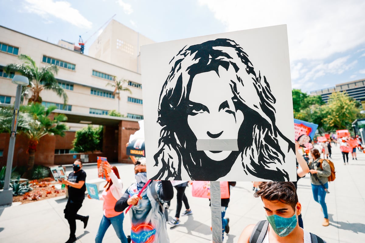 People carrying a Britney Spears image in outdoor rally