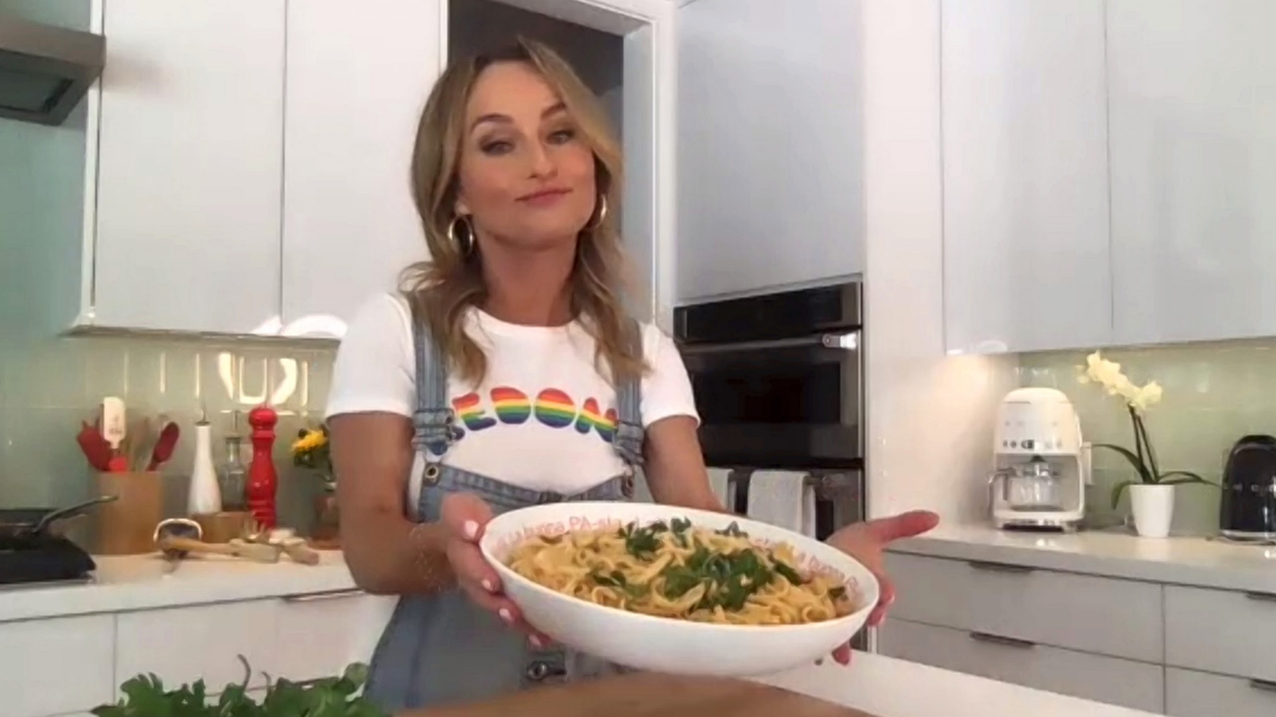 Food Network star Giada De Laurentiis wears denim coveralls and white T-shirt as she explains how to prepare a recipe.