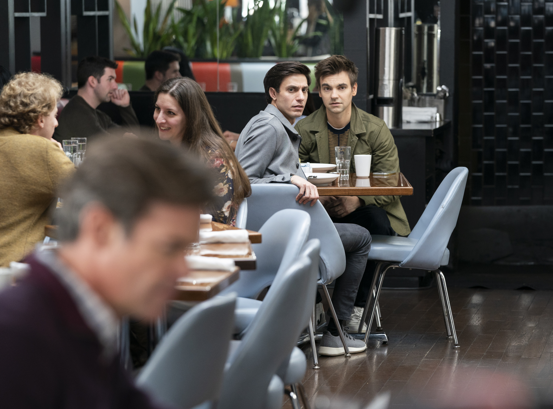 Gideon Glick and Drew Tarver recognize the father and son at a nearby restaurant table in 'The Other Two.'