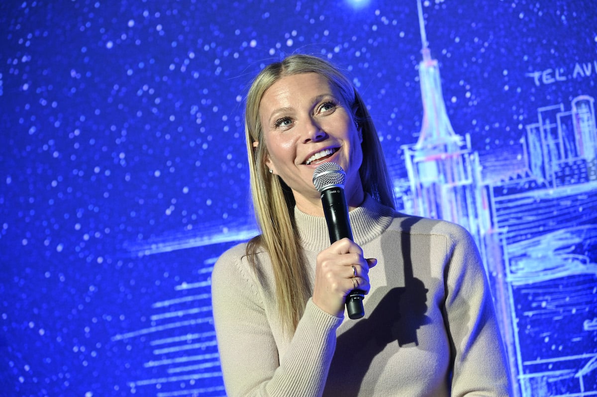 Gwyneth Paltrow holds a microphone and speaks on stage