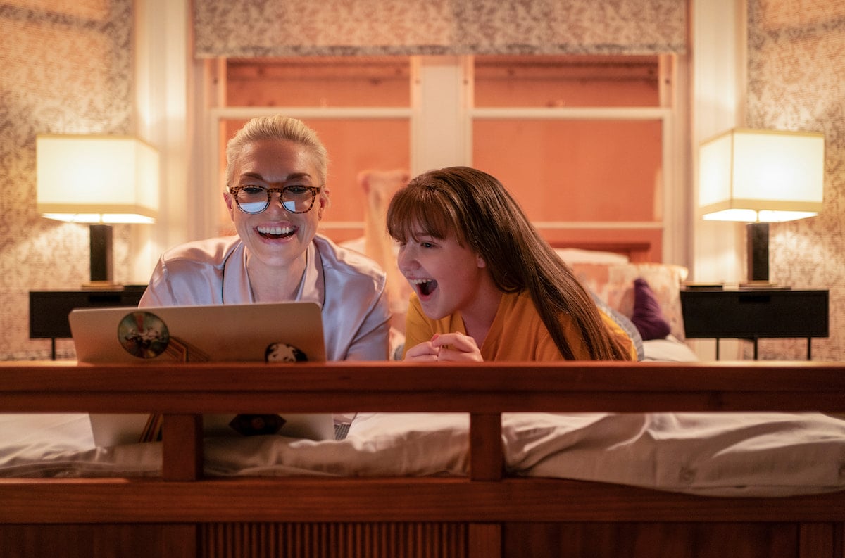 Hannah Waddingham and Kiki May smile as they lay on a bed and look at a laptop in 'Ted Lasso' Season 2