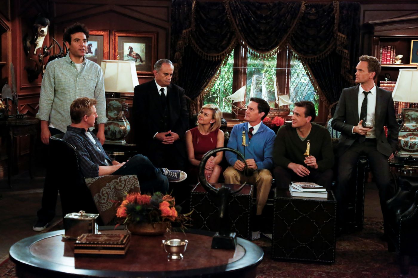 'How I Met Your Mother' scene and cast in a room with wood walls.