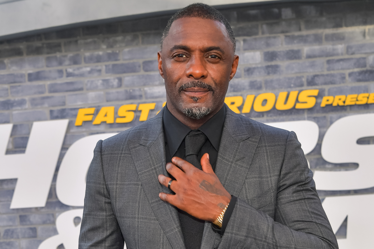 Idris Elba at movie premiere wearing grey and black suit