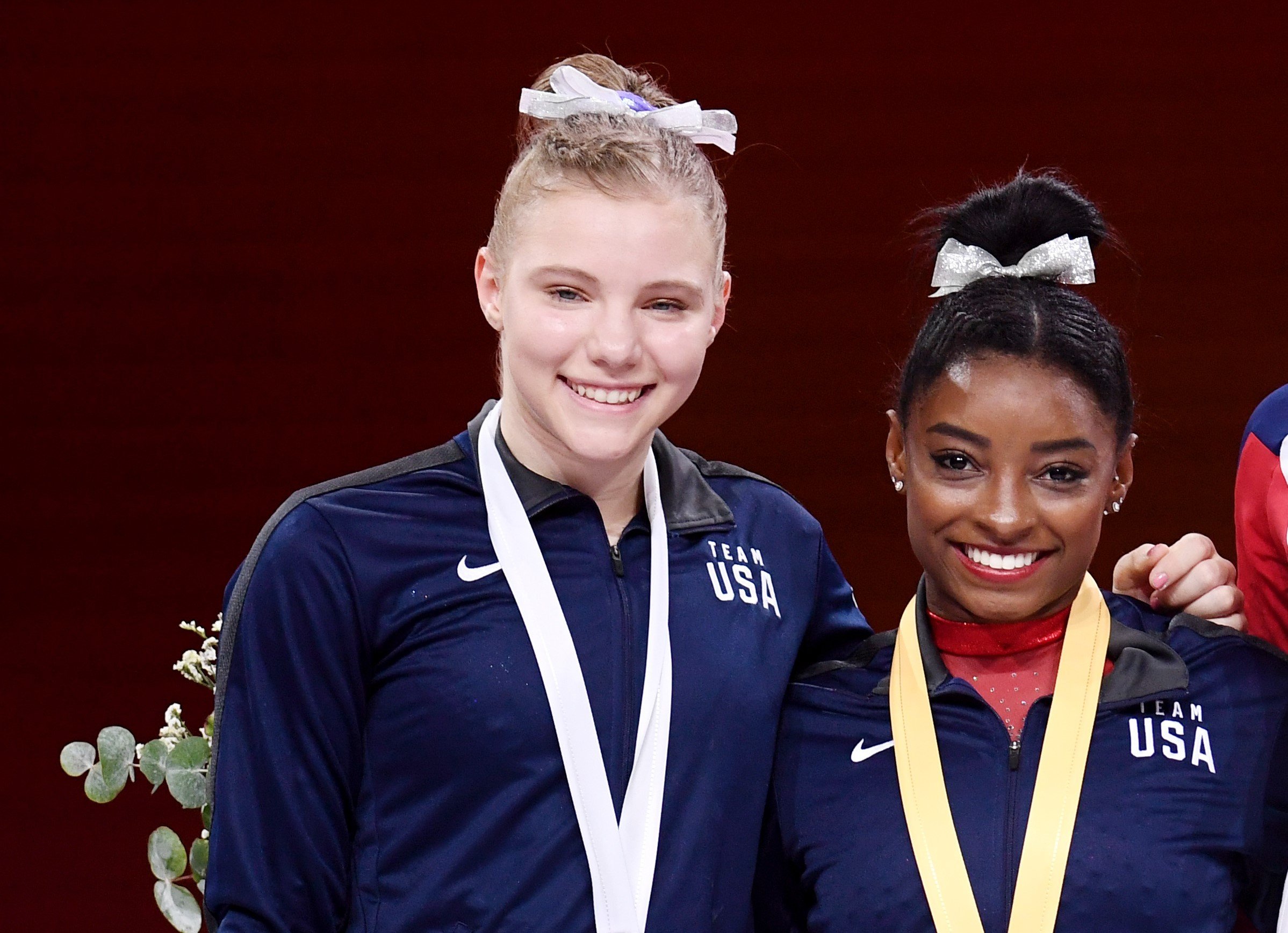 Jade Carey and Simone Biles pose together on the podium with medals at FIG Artistic Gymnastics World Championships