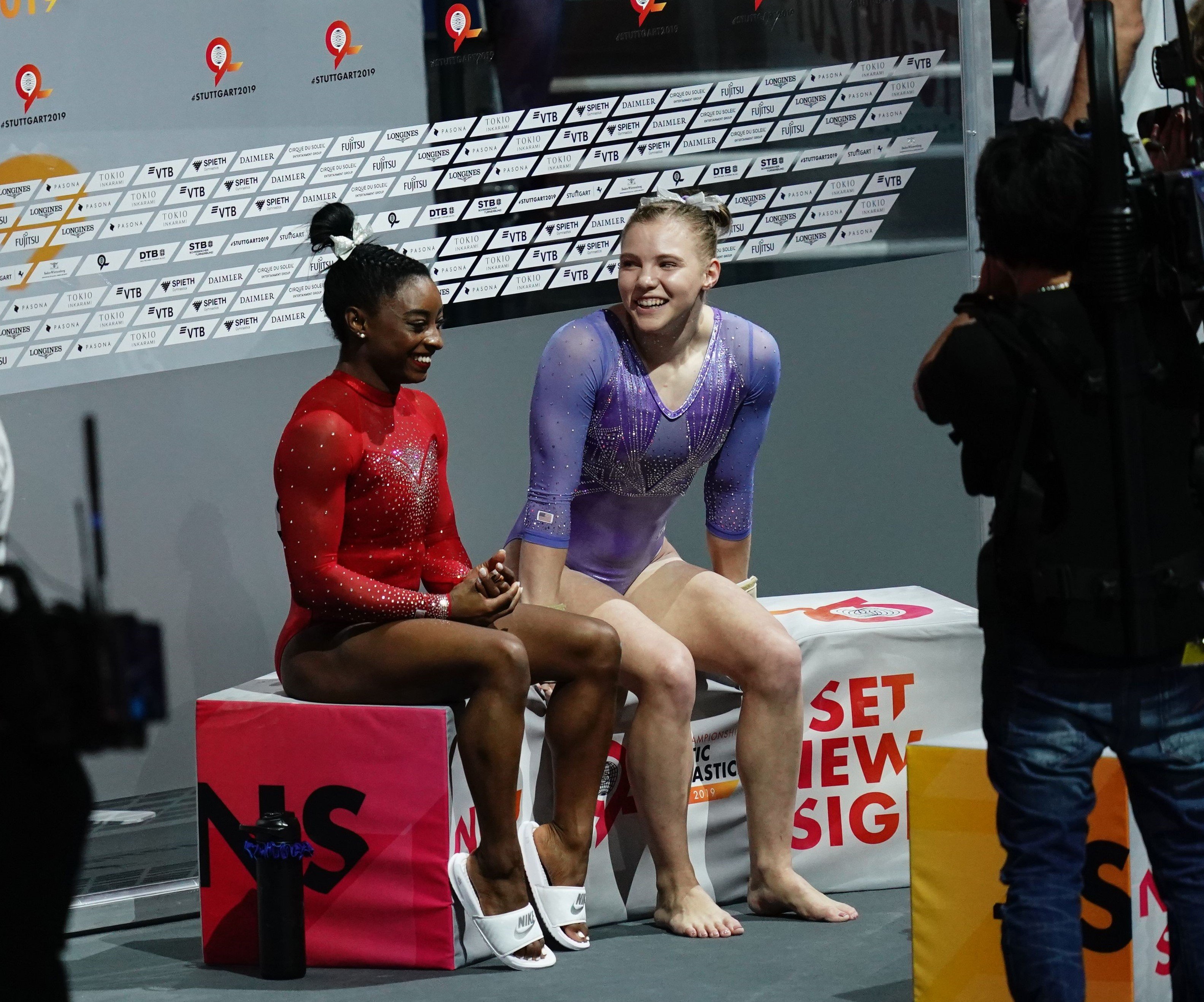 Jade Carey and Simone Biles sitting down next to each other after performing at the FIG Artistic Gymnastics World Championships