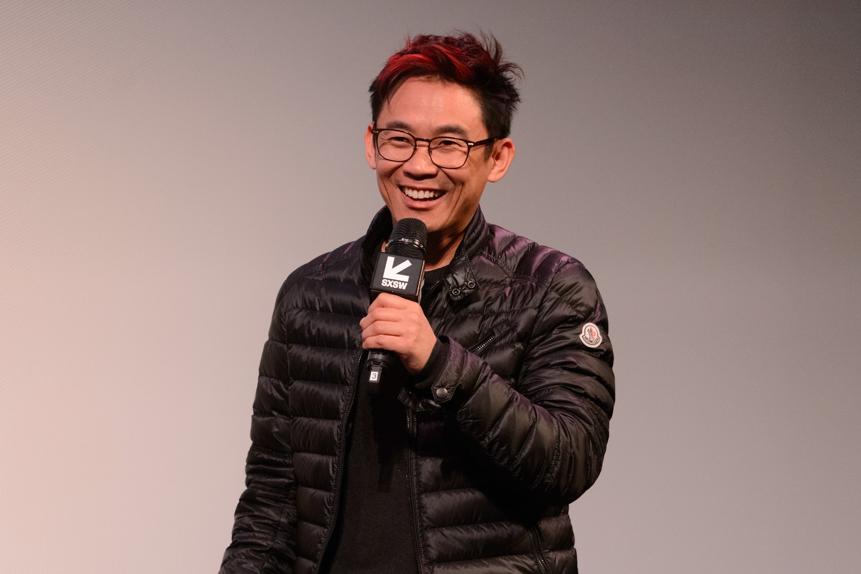 James Wan holding a microphone at a Q&A about his movie 'The Curse of La Llorona.'