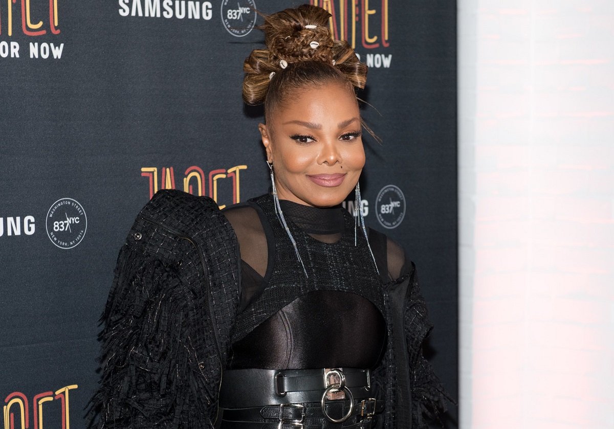 Janet Jackson posing on the red carpet in an all black ensemble