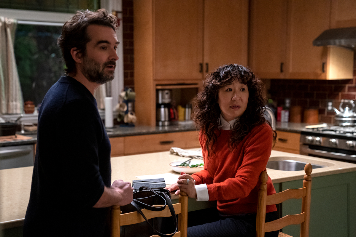 Jay Duplass and Sandra Oh stand at a kitchen island and look on in 'The Chair' Season 1 Episode 4