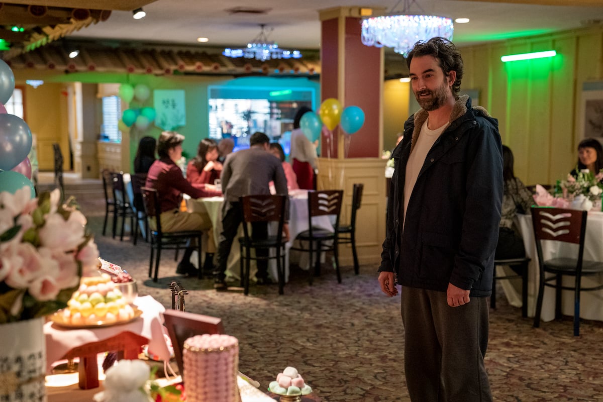 Jay Duplass smiles as he looks at food in 'The Chair' Season 1 Episode 5