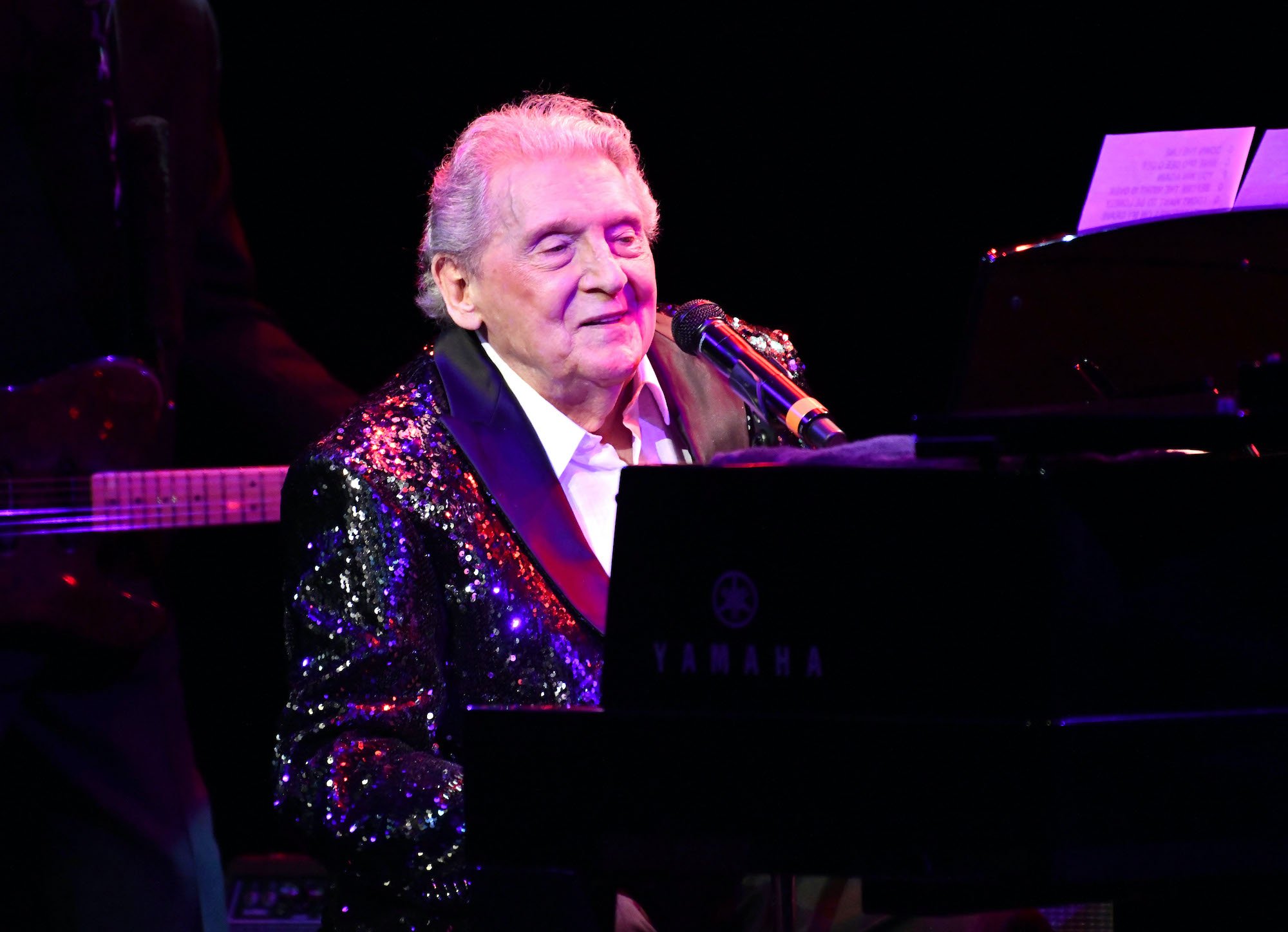 Jerry Lee Lewis smiling, seated at a piano