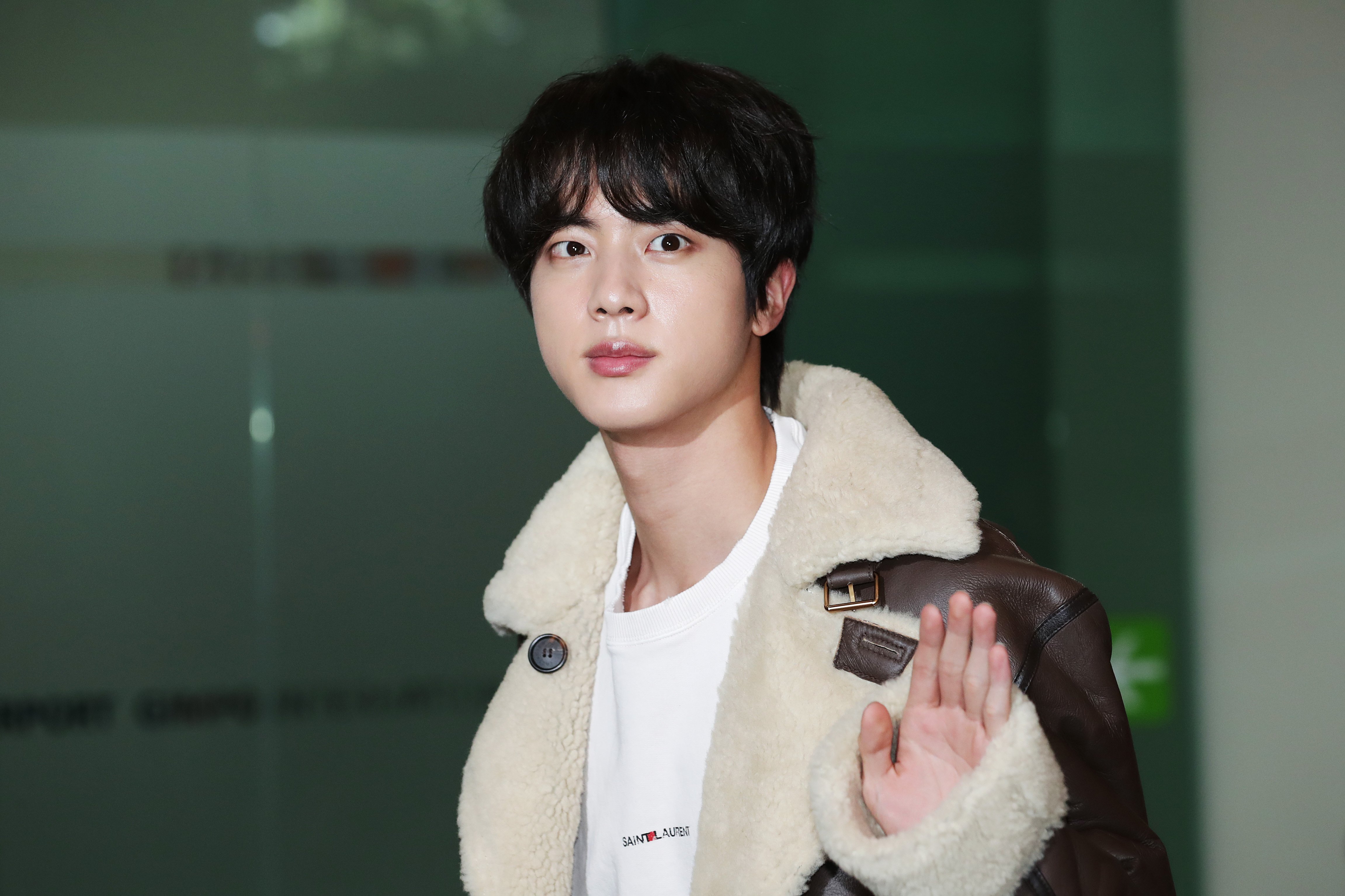 Jin of boy band BTS is seen on departure at Gimpo International Airport waving at fans