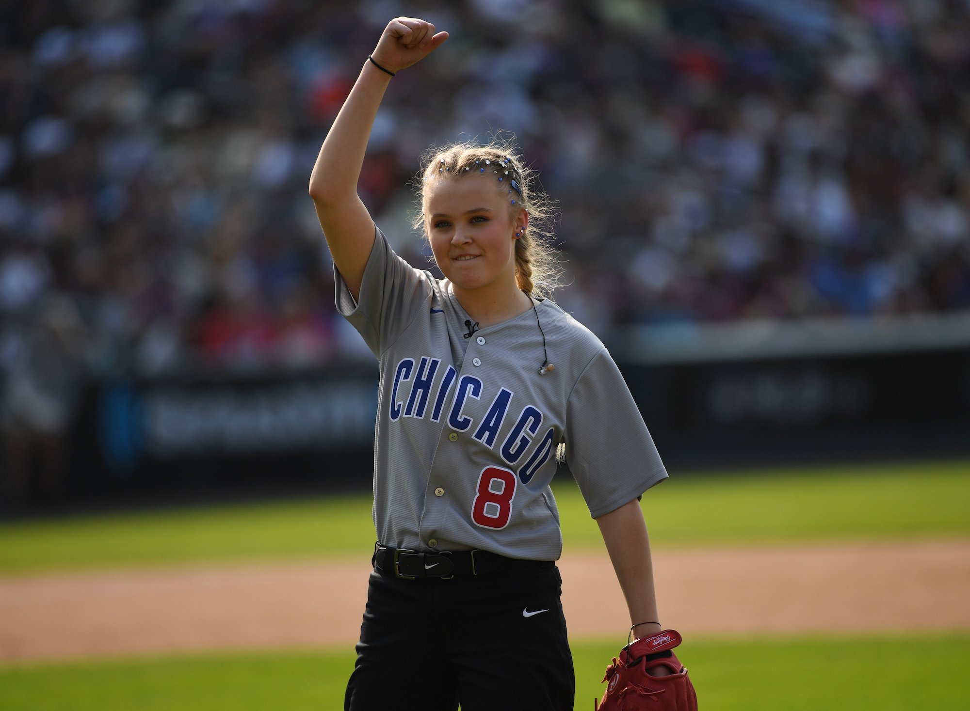 JoJo Siwa pumps her fist on the baseball diamond