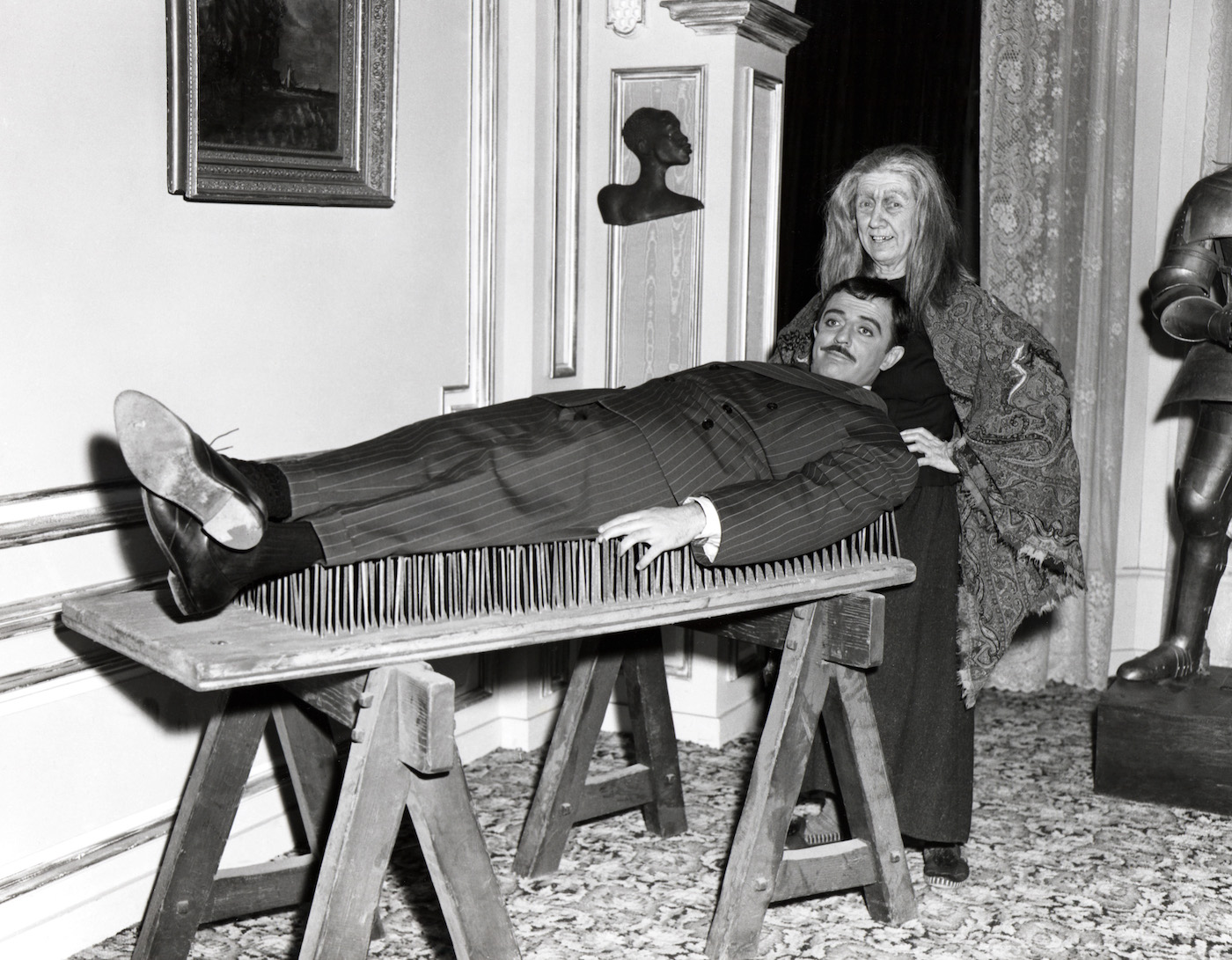 'The Addams Family,' June 30, 1964: Grandmama (Blossom Rock) helps Gomez (John Astin) relax on a bed of nails