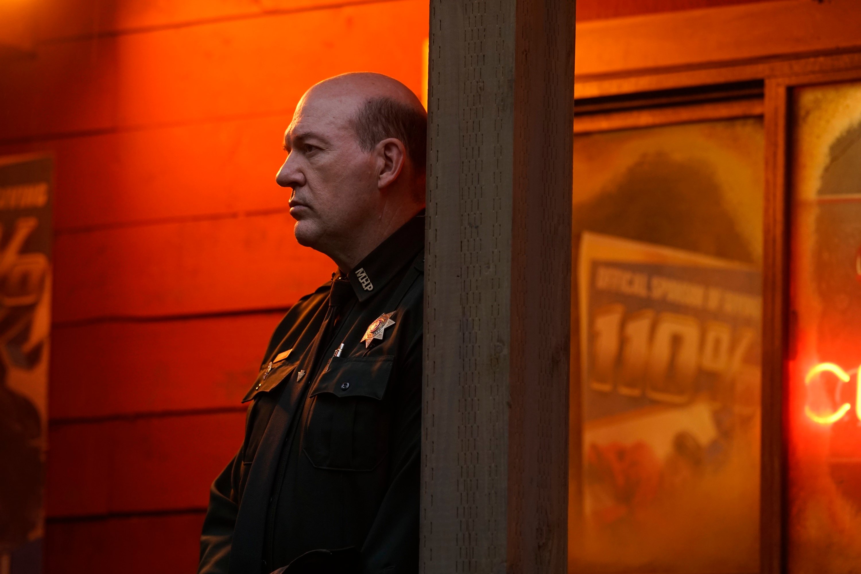 Big Sky star John Carroll Lynch standing against a pole as Rick Lagarski in season 1