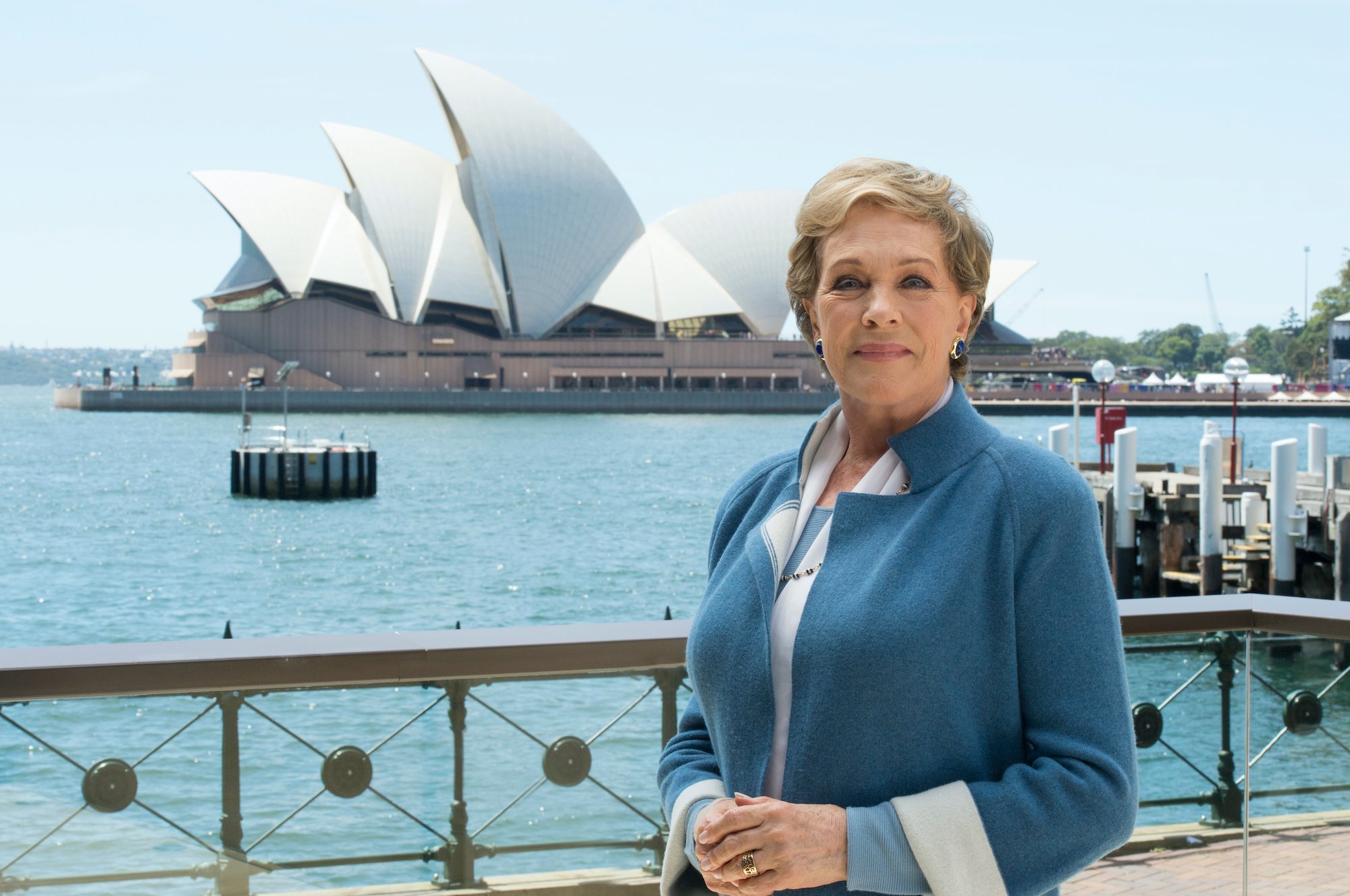 Julie Andrews smiling in front of the Sydney Opera House