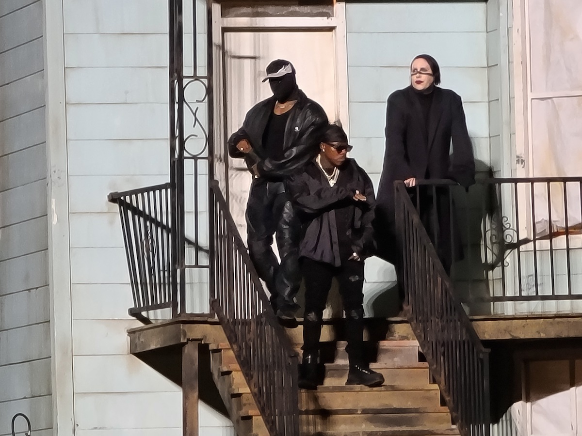 Kanye West, Marilyn Manson, and DaBaby on stage at West's 'Donda' listening party in Chicago. The three musicians pose on the porch of a replica of West's childhood home.