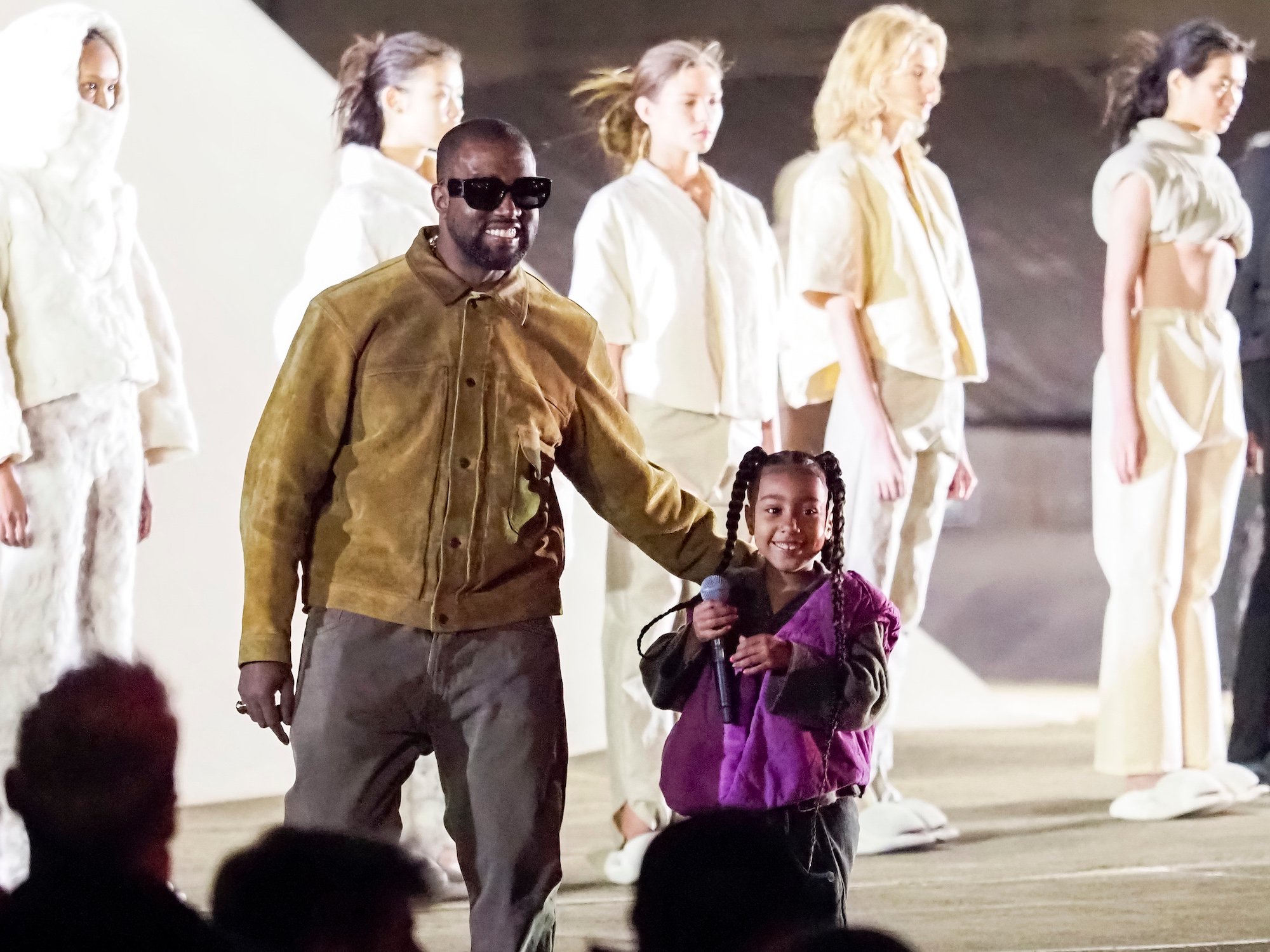 Kanye West and North West smiling on a runway