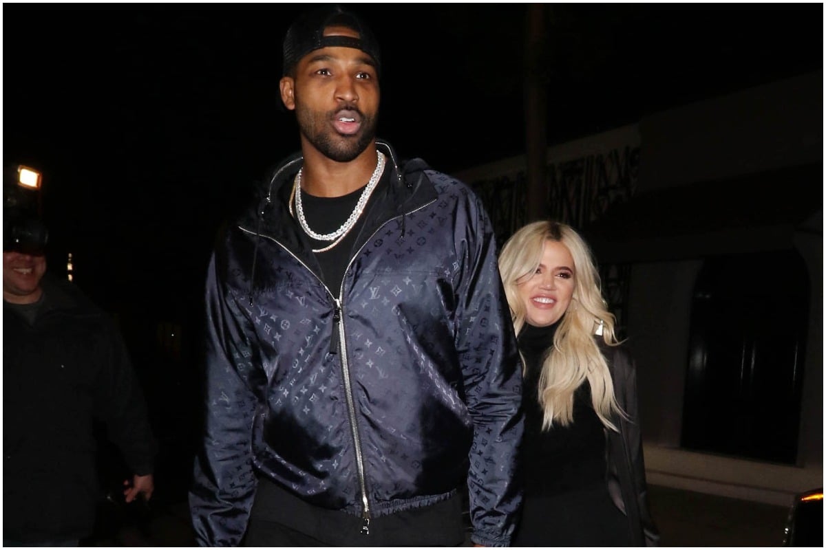 Khloé Kardashian and Tristan Thompson smiling and walking together during a night out.