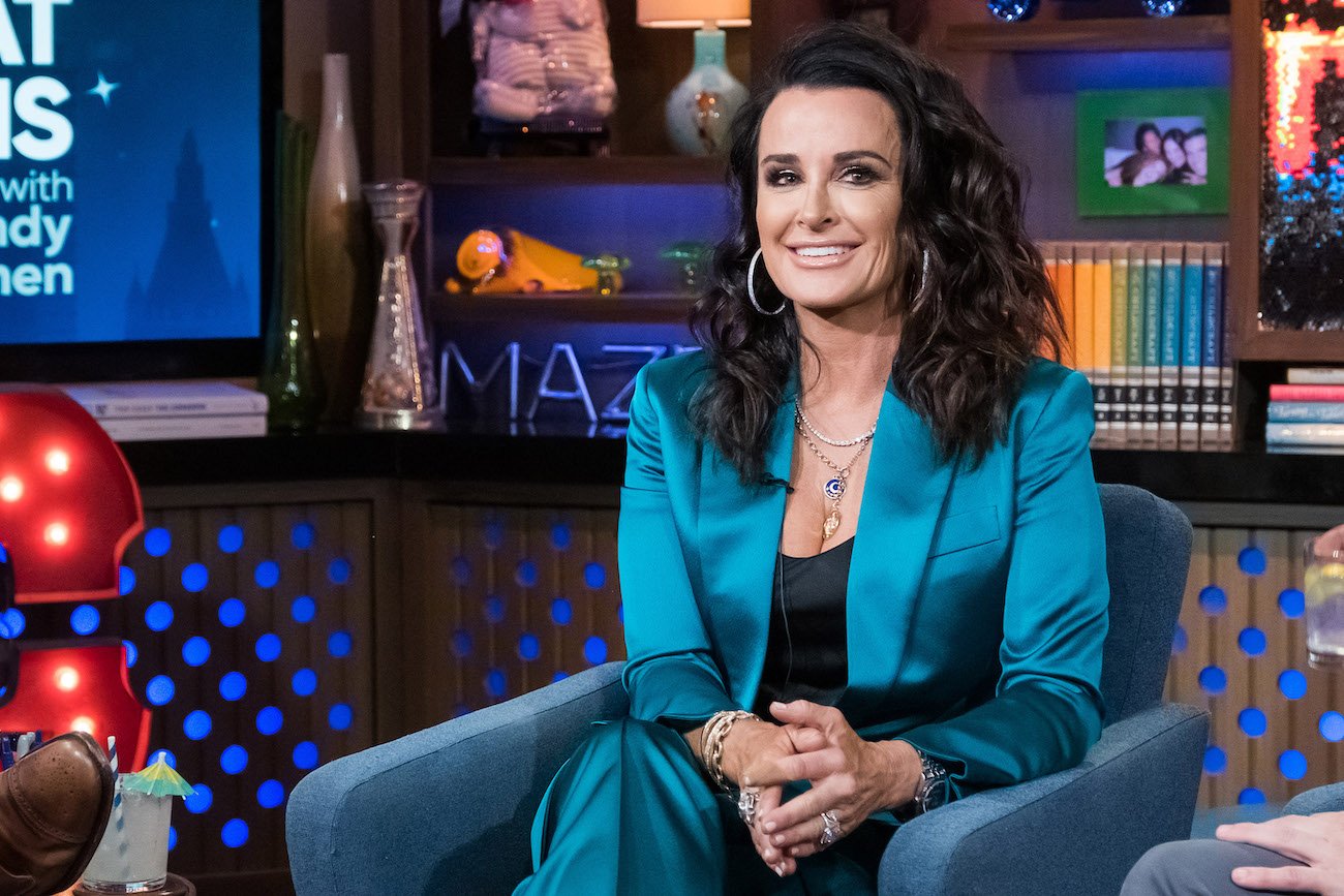 Kyle Richards in a blue outfit, sitting on a blue chair