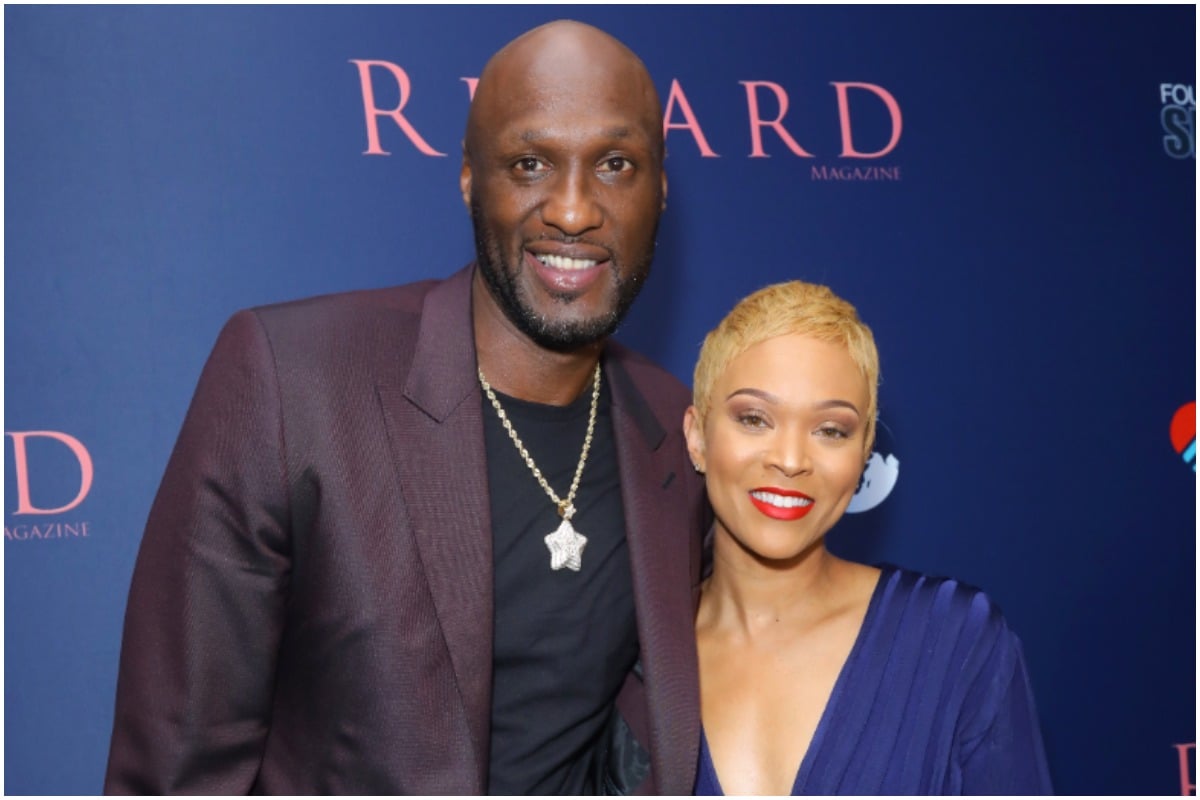 Lamar Odom and Sabrina Parr smiling and posing for the camera at an event.
