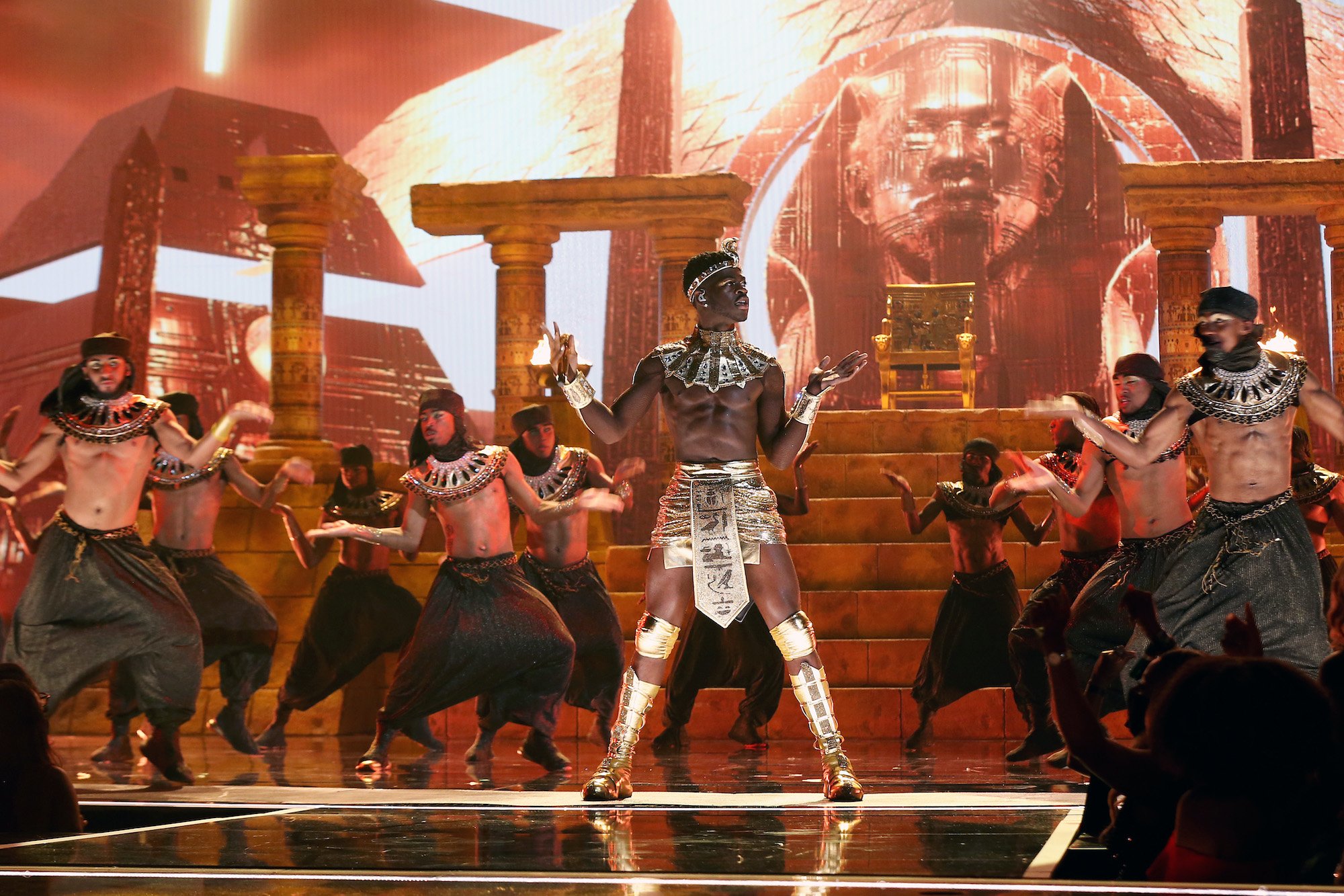 Lil Nas X performing onstage surrounded by dancers