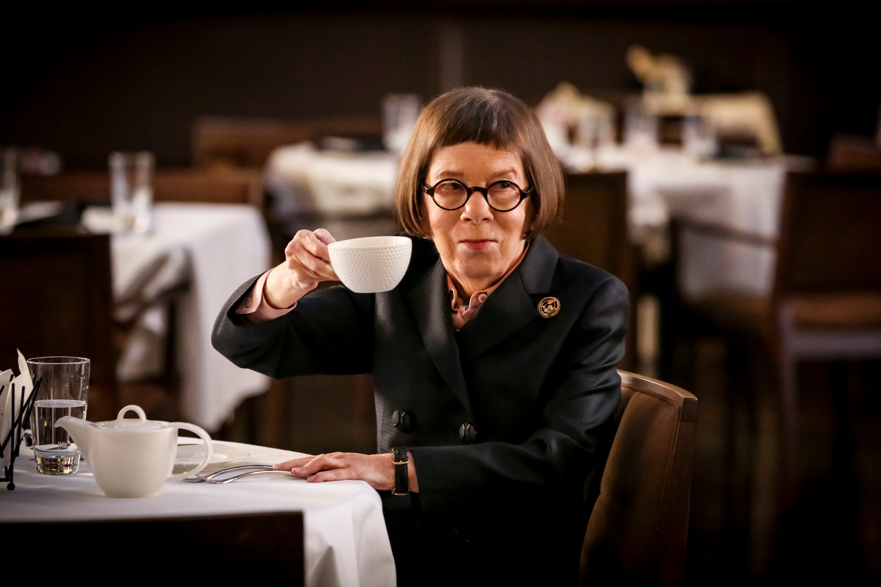 Linda Hunt raises a tea cup during a scene from NCIS: Los Angeles.