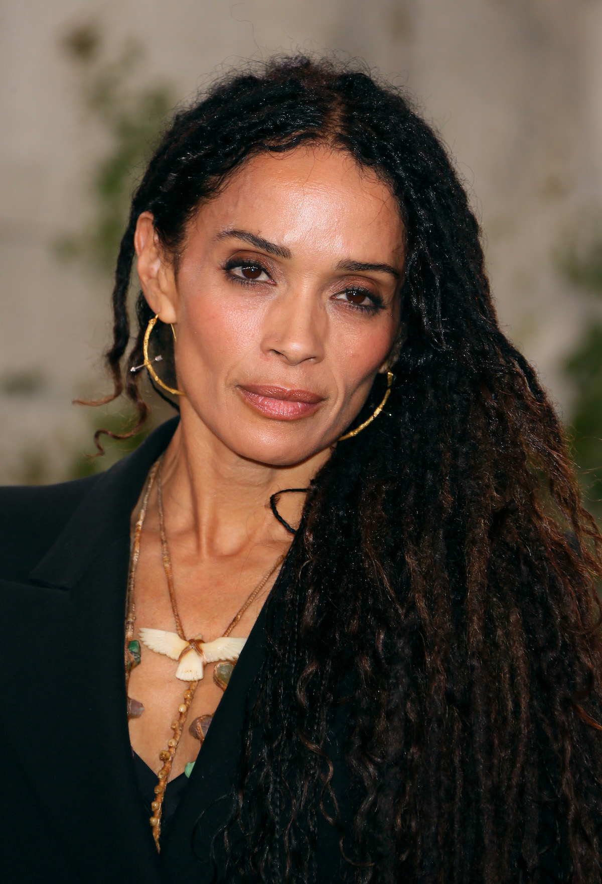 Lisa Bonet smolders for the camera in a black outfit and gold jewelry at an event.