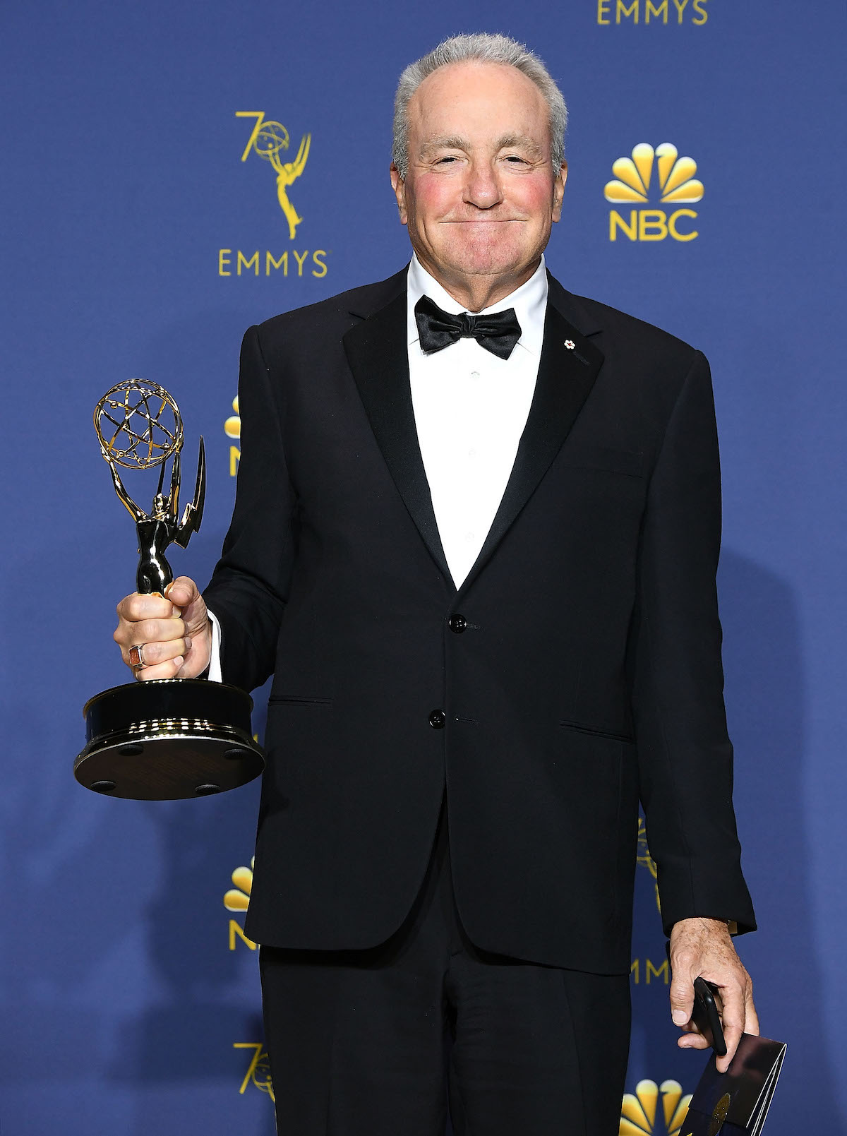 Lorne Michaels in a tuxedo smiling and holding an Emmy Award.