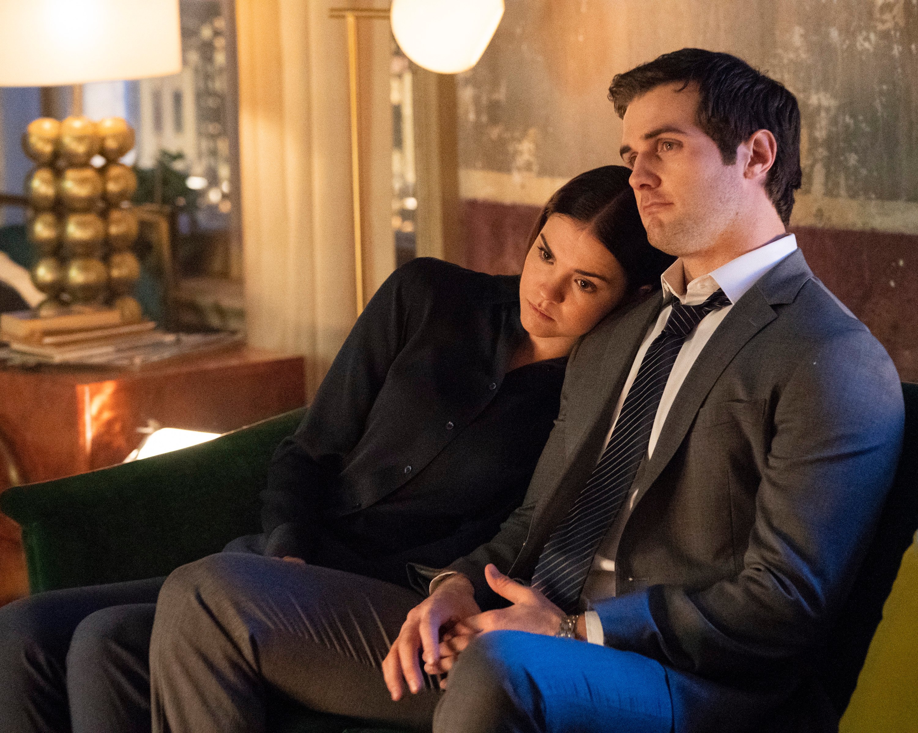 Maia Mitchell and Beau Mirchoff sit on a couch during a scene from 'Good Trouble.'