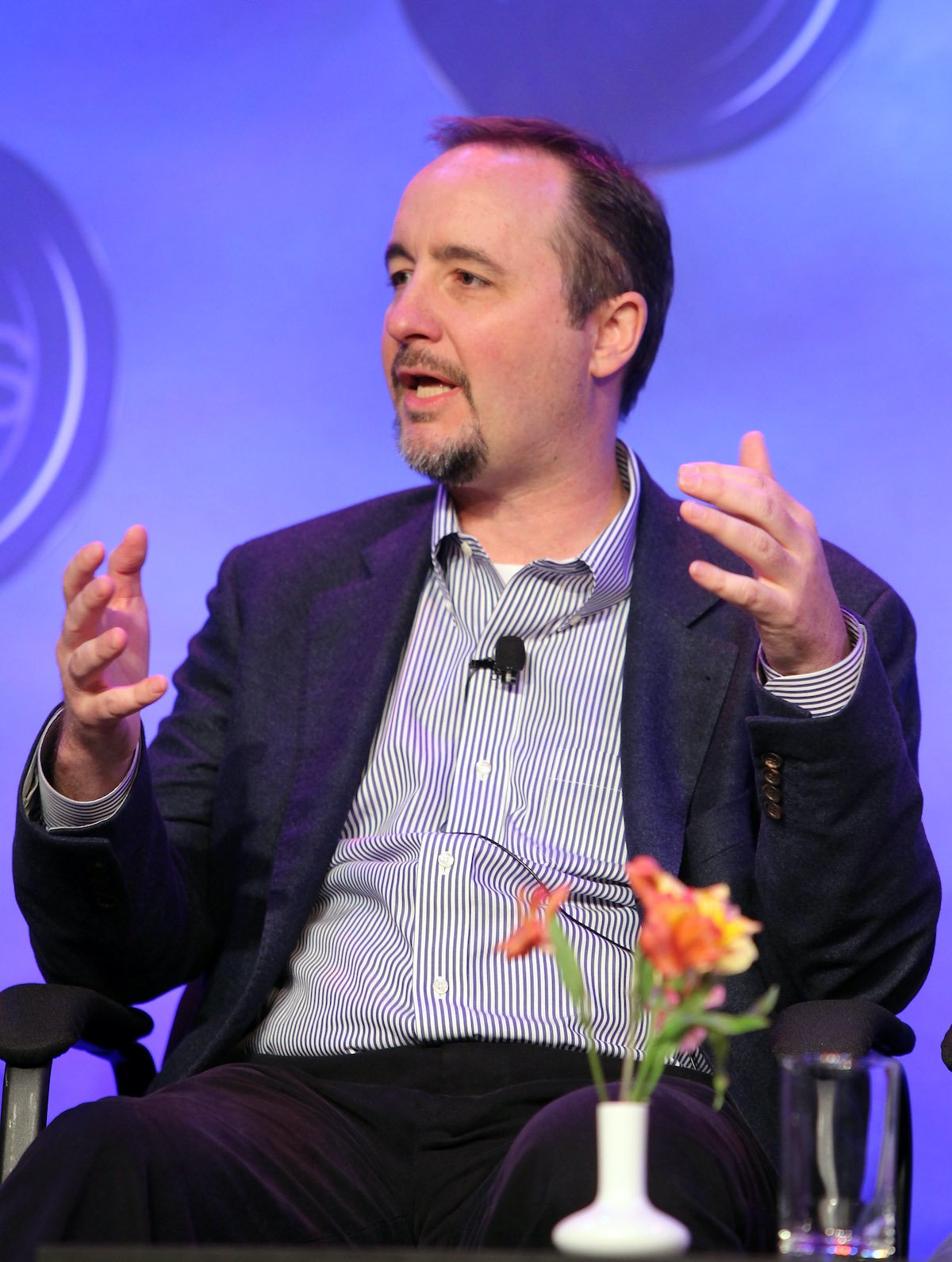 'Below Deck' executive producer Mark Cronin wearing a blue jacket speaks on stage during an event. 