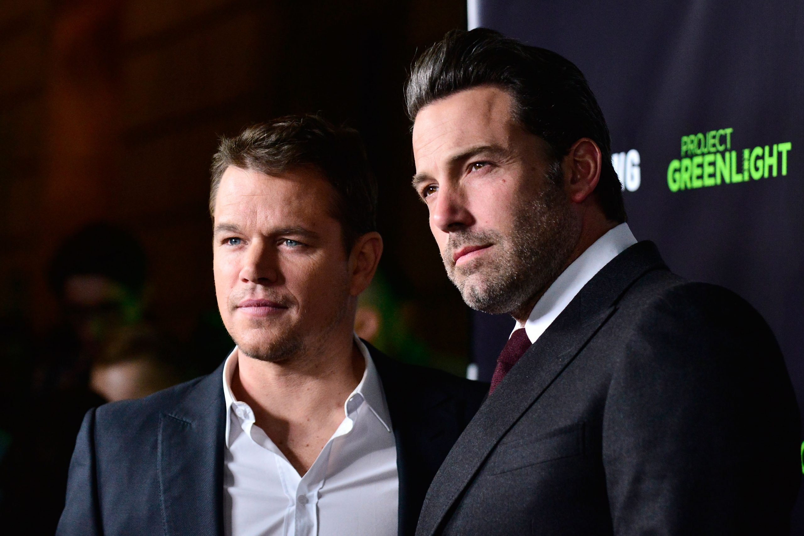 Matt Damon and Ben Affleck looking at cameras at event